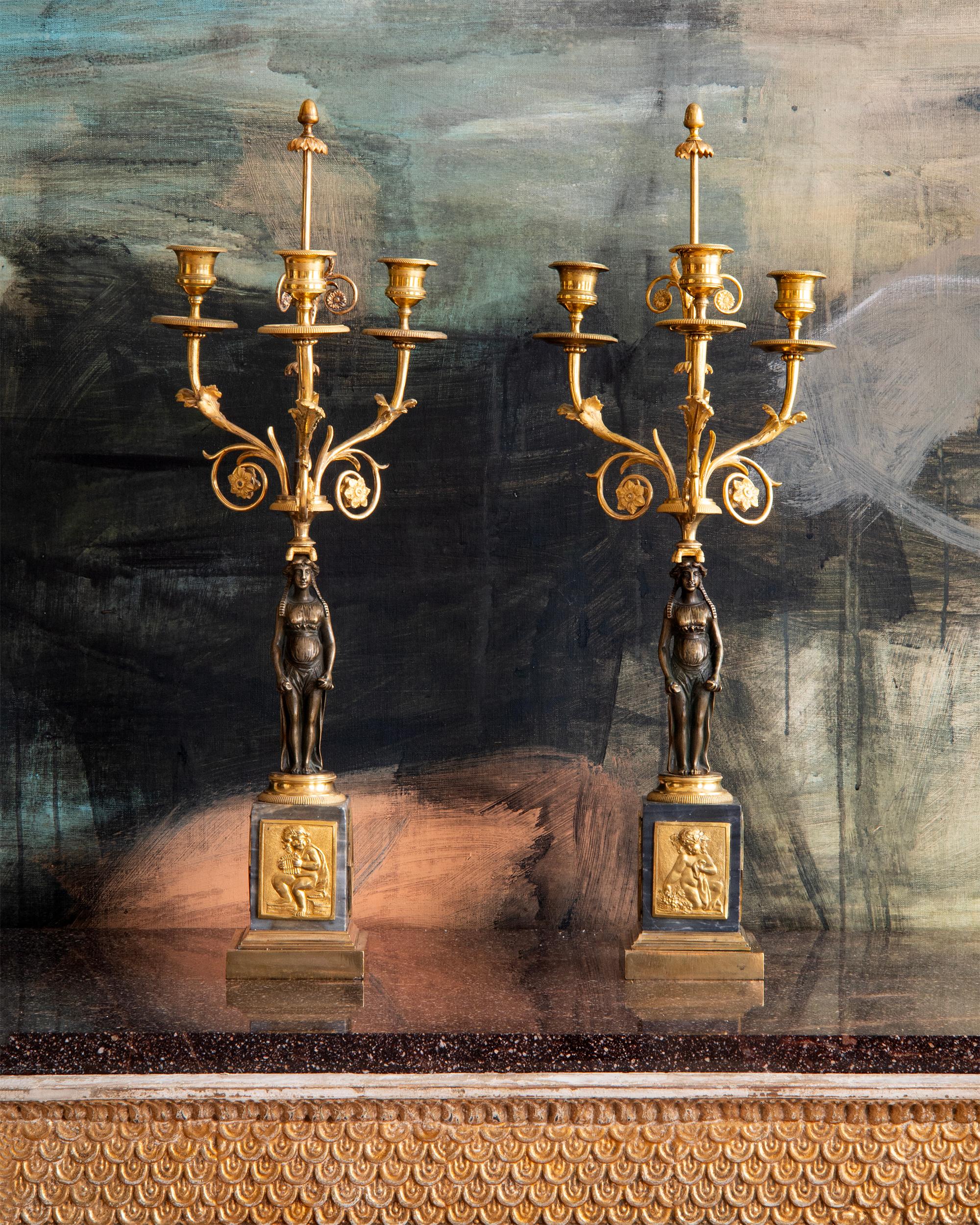 Raffinata coppia di candelabri a tre luci gustaviani del XVIII secolo. Bronzo dorato e marmo (Bleu Turquin) con una cariatide che sostiene tre bracci a candela ornati di fogliame, piedistallo in marmo con ornamenti bacchici a rilievo. 1790 circa,