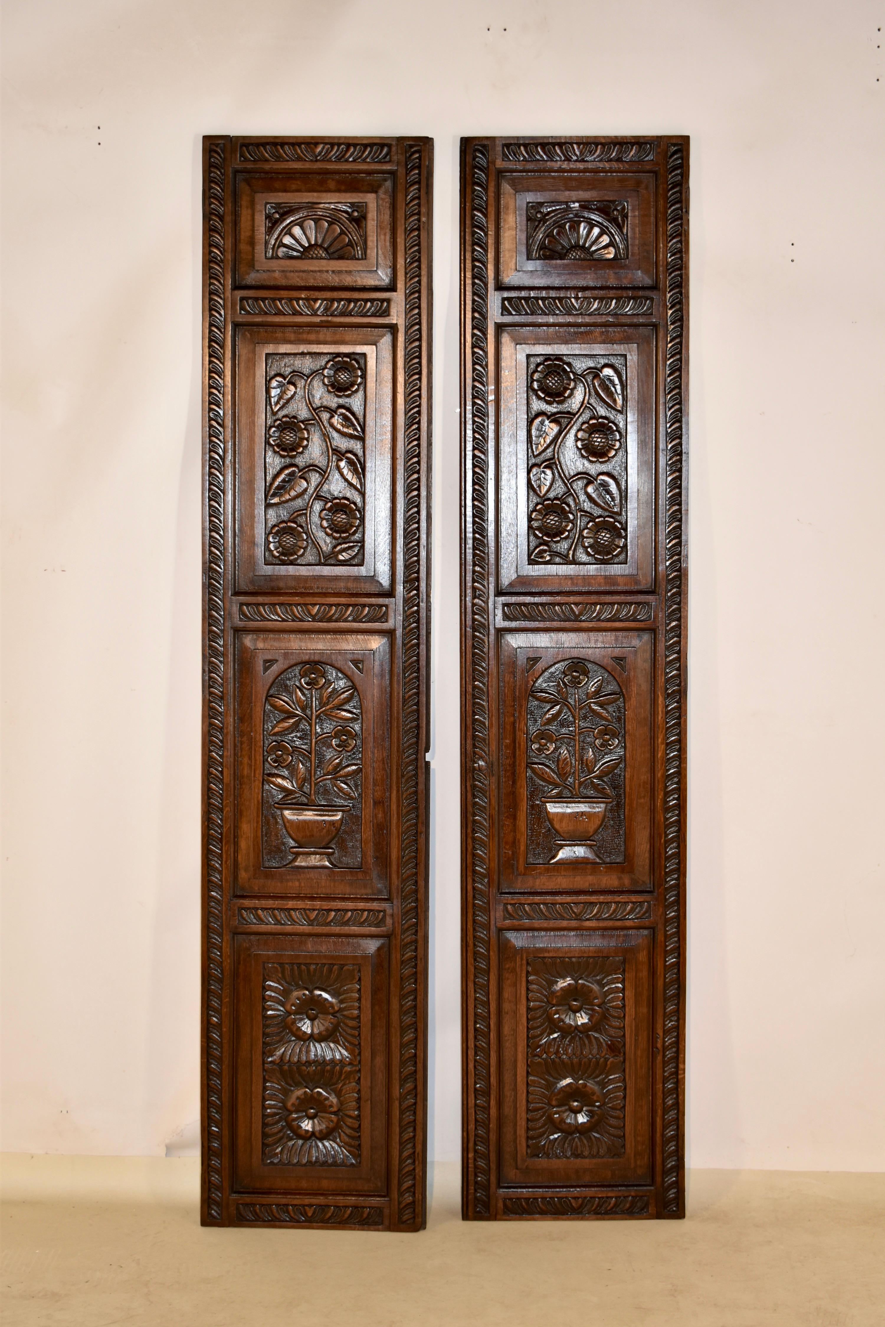Pair of 18th century hand carved panels. They have hand carved banding surrounding raised panels with hand carved designs, including florals, vines, and carved transom like patterns at the tops. Wonderful hand planing on the backs.