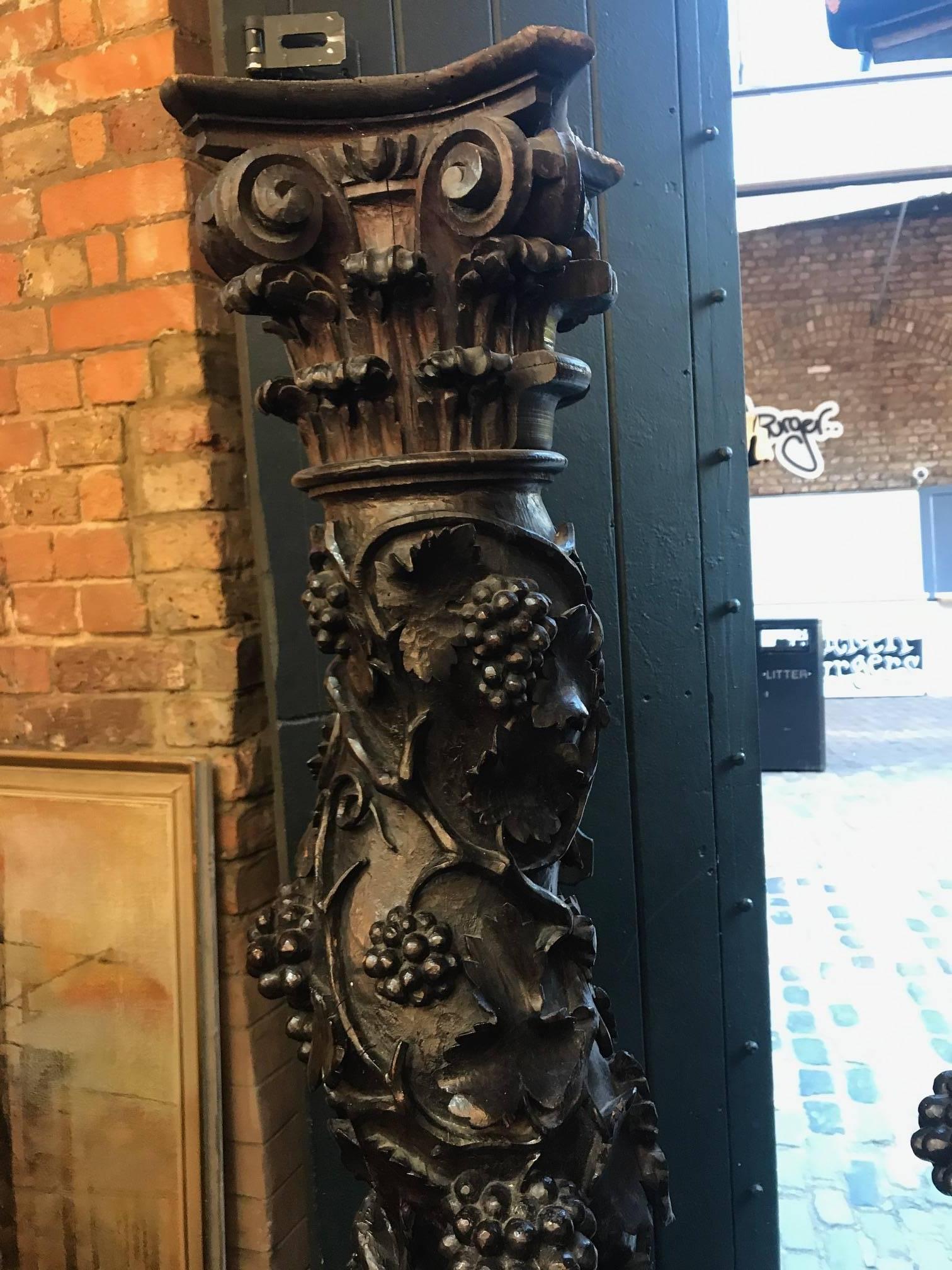A pair of 18th century hand-carved wooden columns, with a grape vine motif. The columns have been formed from a single piece of wood. They originate from a country house in Hertforshire, England.