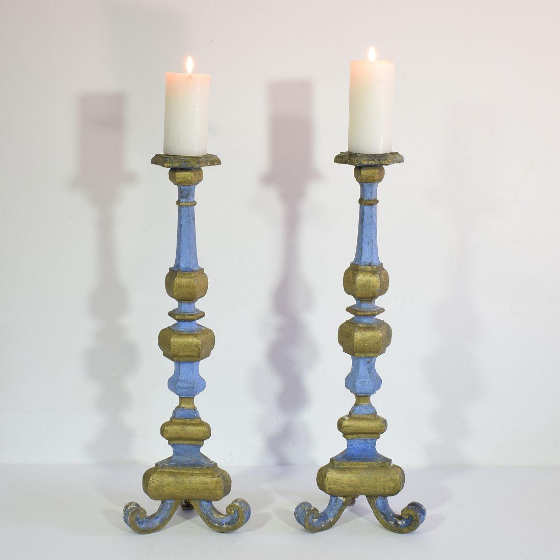 Great pair of baroque carved wooden candleholders with a stunning old color, Italy, circa 1750-1780. Weathered, repairs and losses. Measurement individual.