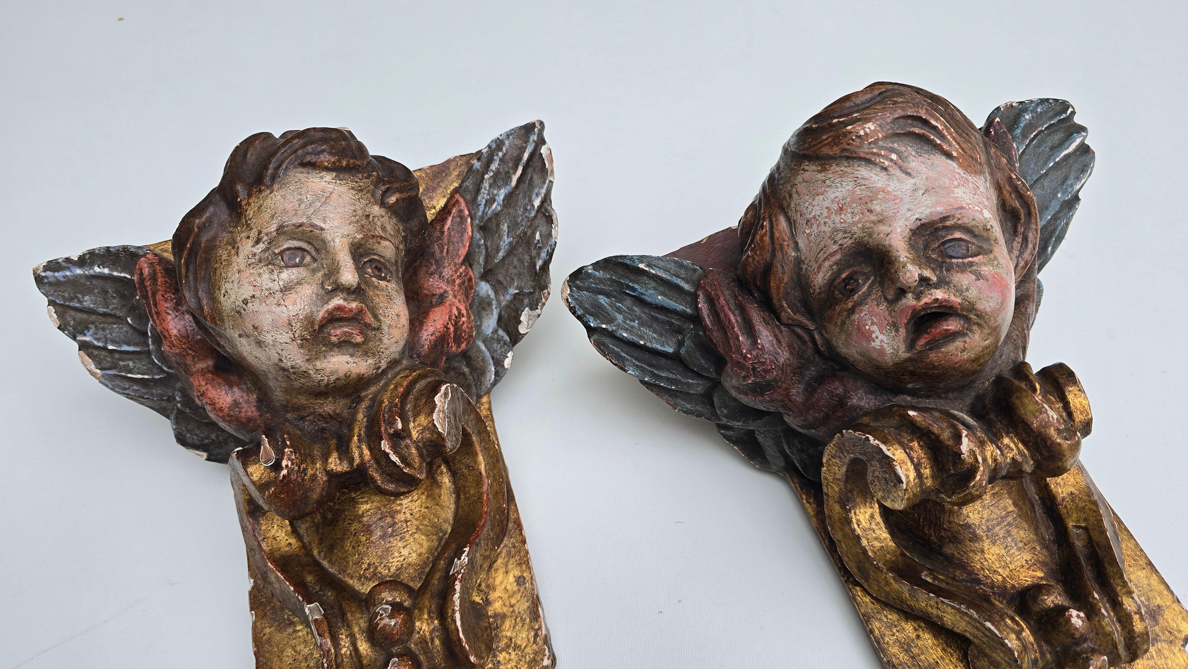 An exceptional pair of 18th century Italian Baroque cherub corner carvings. Hand carved in solid wood and retaining their original polychrome and gilded surfaces. Each cherub presents a remarkably expressive face, one with an uplifted look of serene