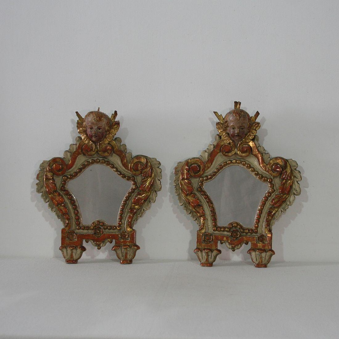 Unique pair of Baroque mirrors with angel heads, original color and gilding, Italy, 18th century. Weathered, small losses and old repairs.