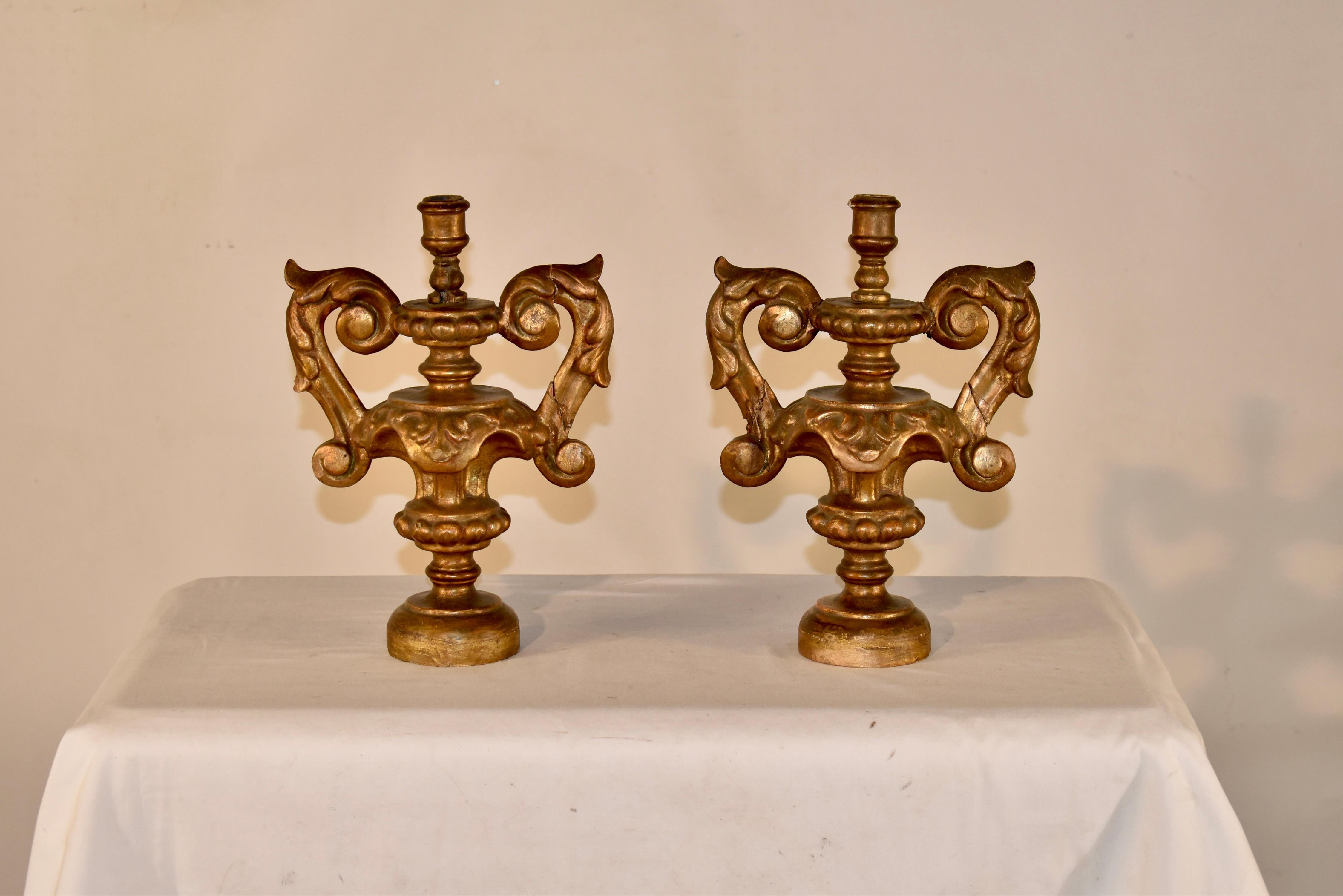 Pair of 18th century gilt wood candlesticks from Italy.  This pair is wonderfully hand carved and has exquisite detail in the arms and central columns.  The work and artistry are gorgeous.  