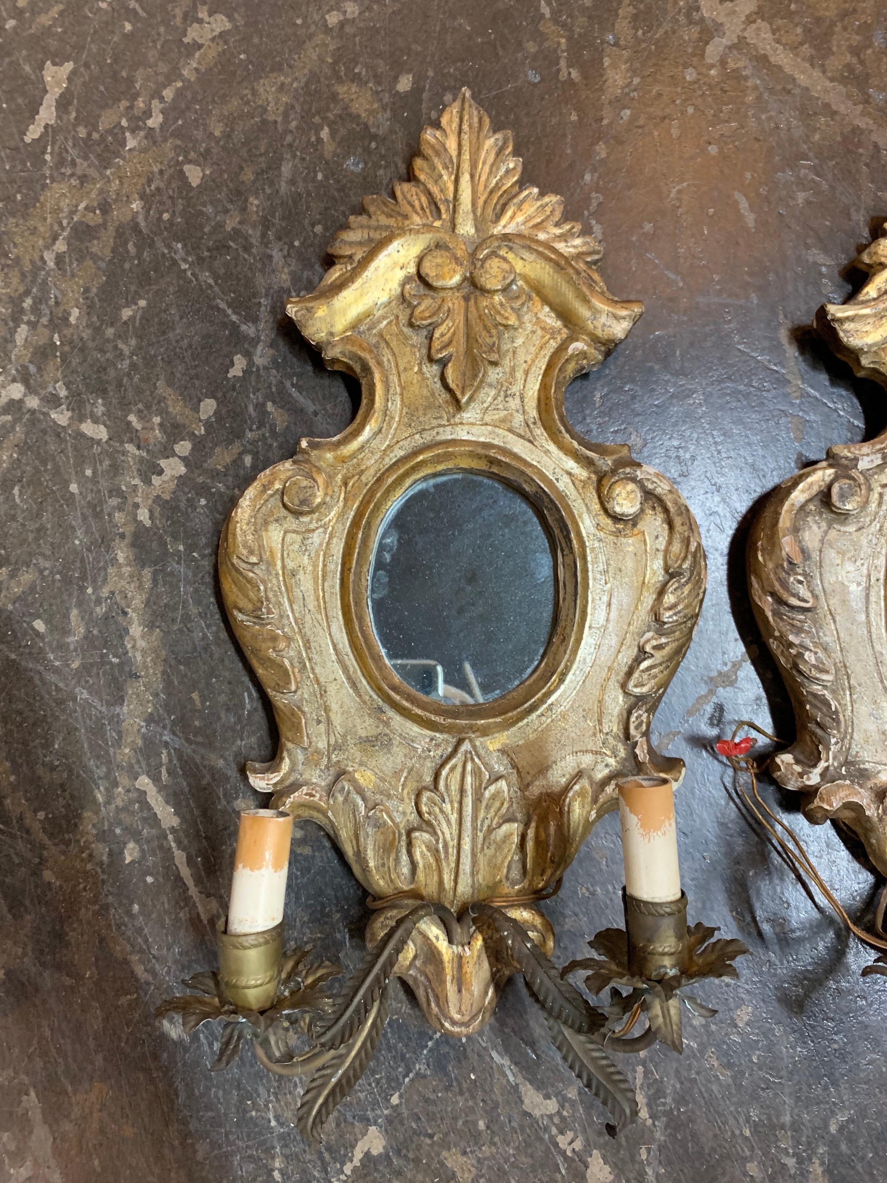 Decorative pair of the 18th century Italian carved and giltwood wall sconces with 2 lights. Nice carving on the giltwood and there is a mirror in the center of the sconces.
These would be a lovely focal point in a beautiful room!