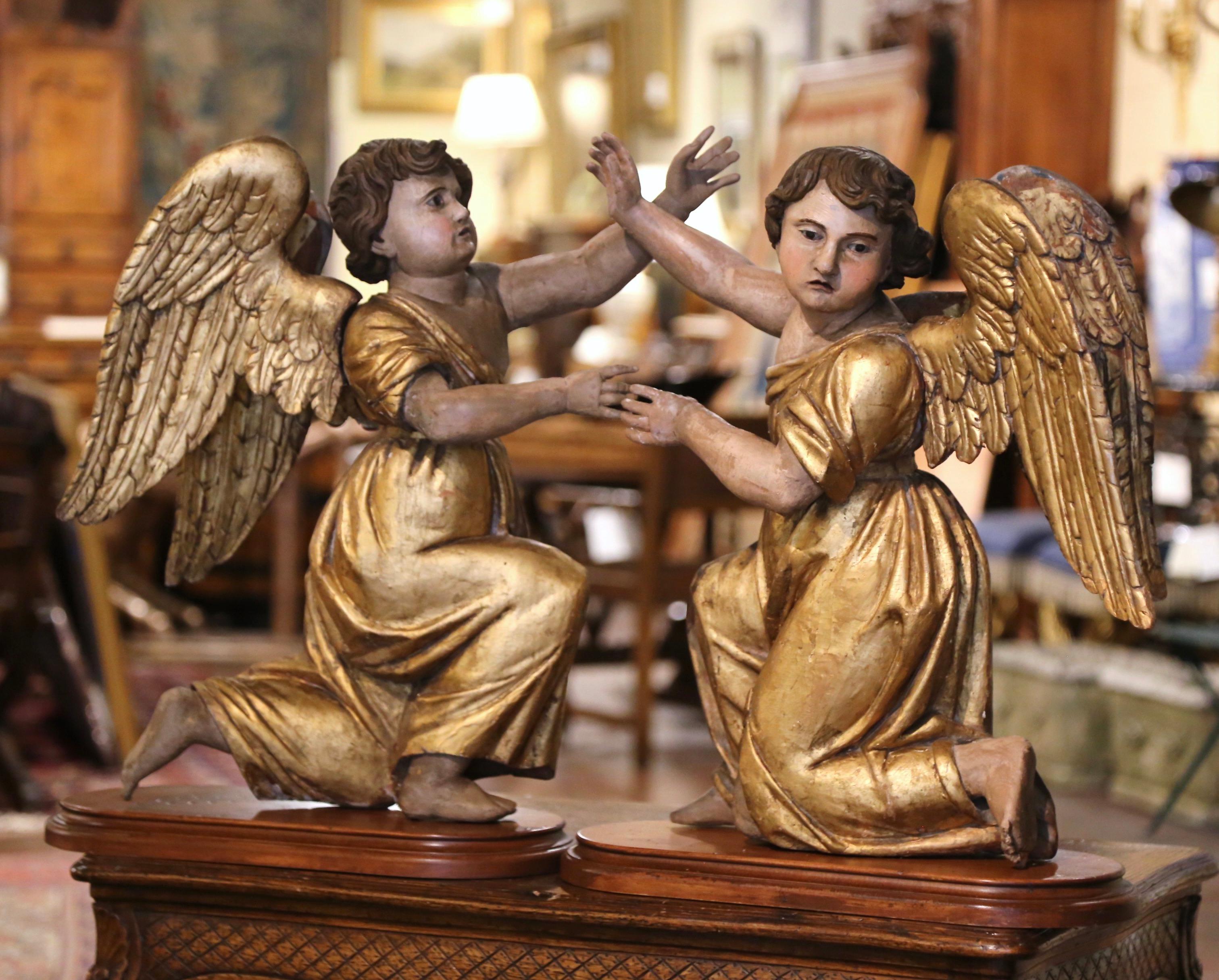 Decorate a mantel or a console with this important pair of antique giltwood angel sculptures. Crafted in Italy circa 1760, each hand carved religious statue features is kneeling in genuflection on a wooden base, and has both arms raised up in