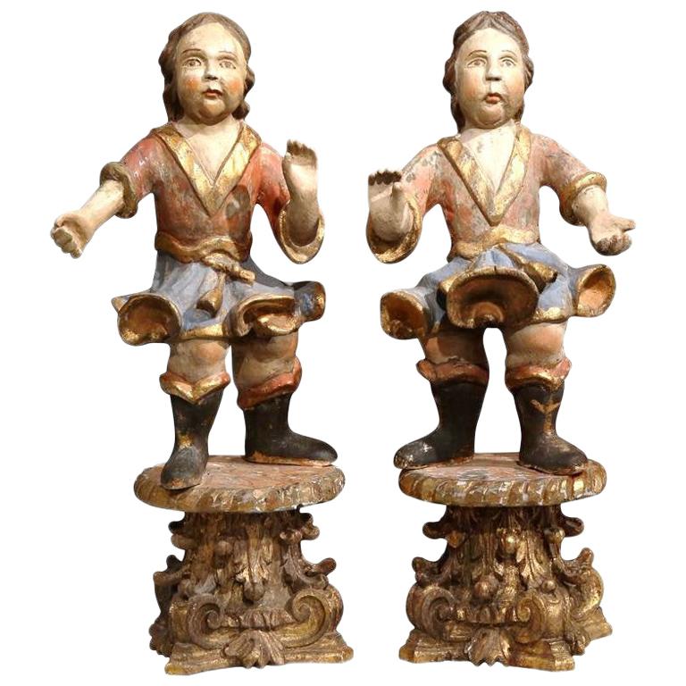 Pareja de esculturas italianas del siglo XVIII de querubines tallados, policromados y dorados