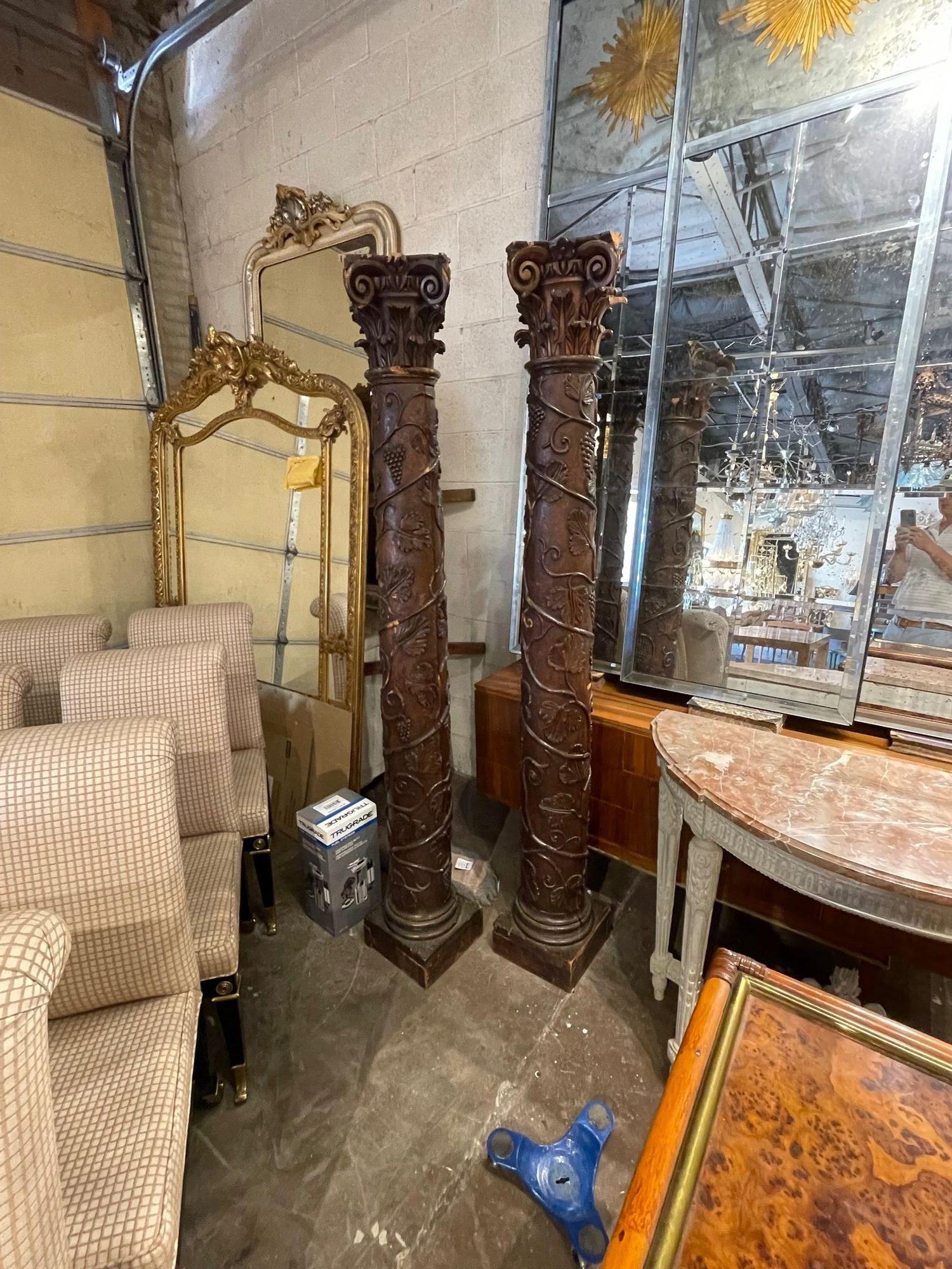 Exceptional large-scale pair of 18th century Italian carved walnut columns. Featuring carvings of a twining vine with leaves, and grapes. Beautiful!!