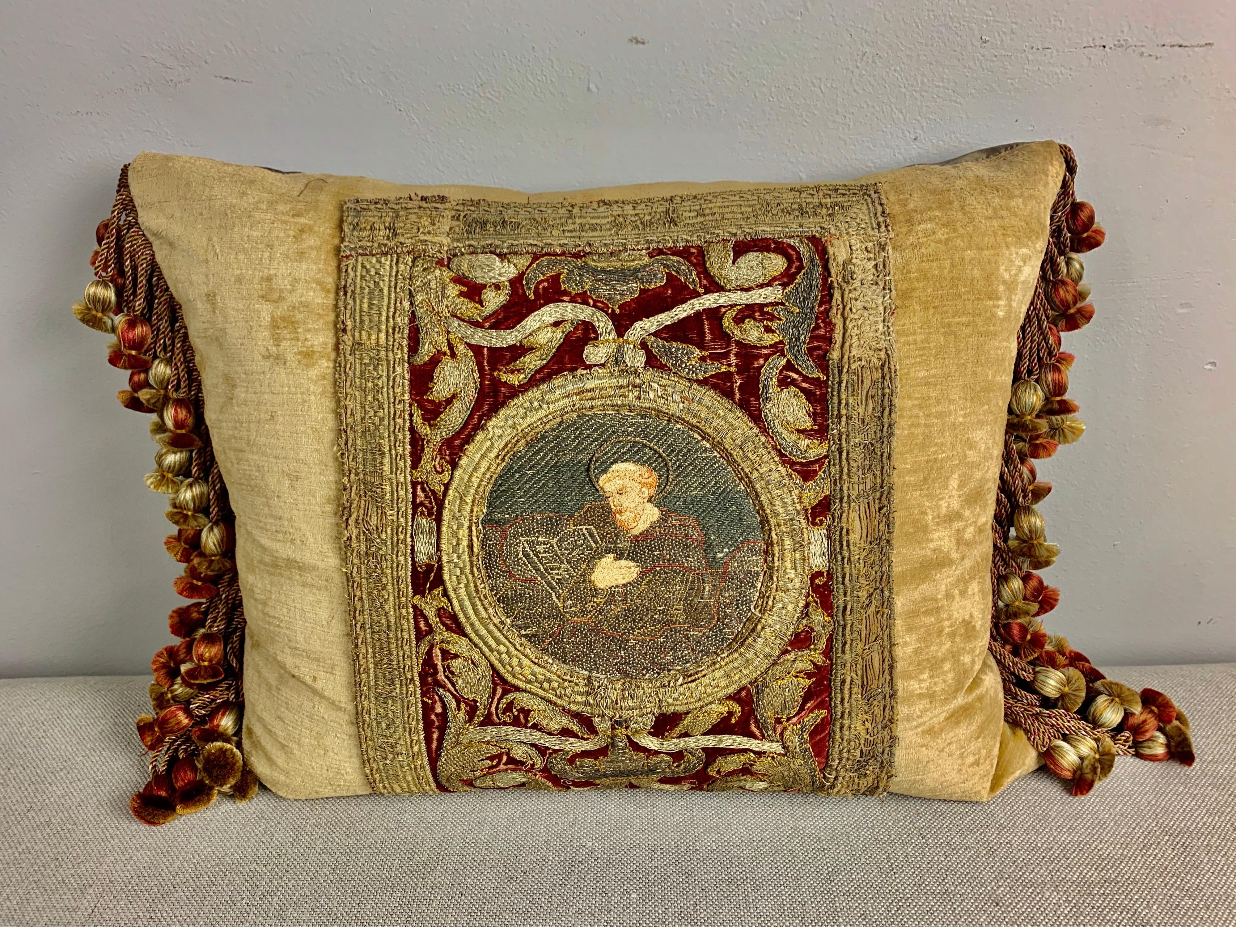 Pair of incredibly fine 18th century metallic and silk embroidered red and gold textile pillows. The pillows depict religious Apostles centered in cartouches and surrounded by more incredible embroidery throughout. Silk taffeta backs, multicolored