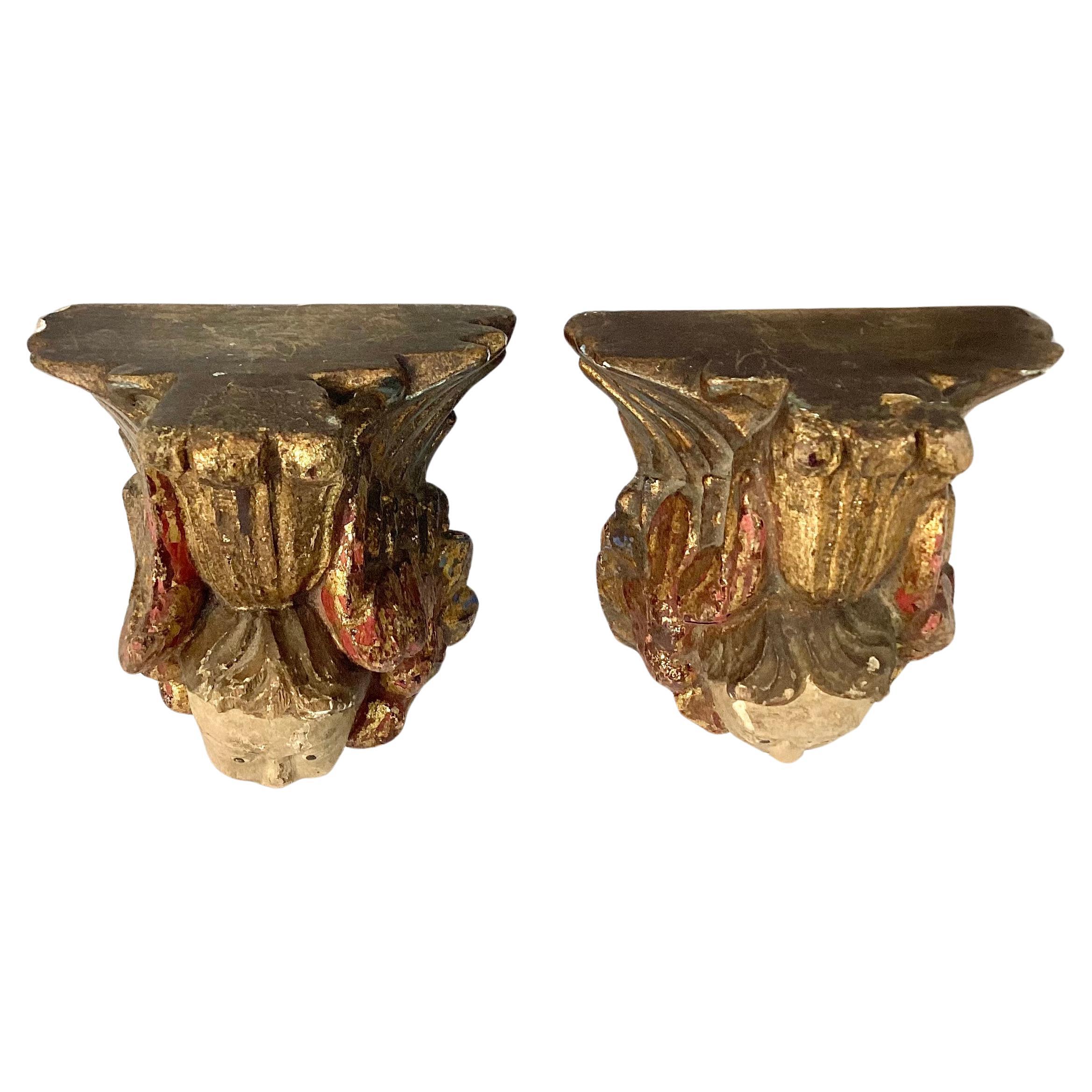 Pair of 18th Century Italian figural carved Angel wall brackets. Brackets feature charming angel faces under small flat shelf. Giltwood and painted, brackets have a wonderful old patina. Hooks on back for hanging. Pair would make a lovely addition