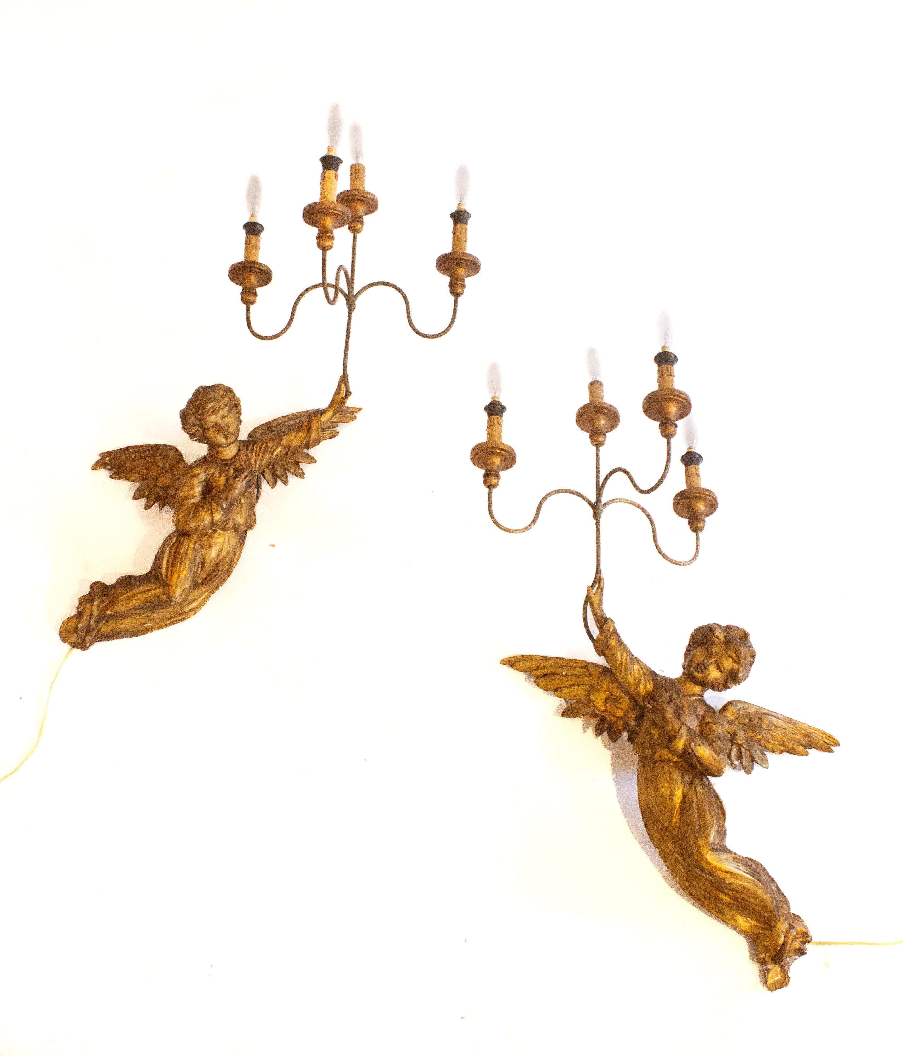 Paire d'appliques italiennes du XVIIIe siècle, dorées et sculptées à la main, destinées à éclairer les anges. La paire d'anges provient d'une représentation angélique dans une église historique italienne. Elles étaient placées de part et d'autre