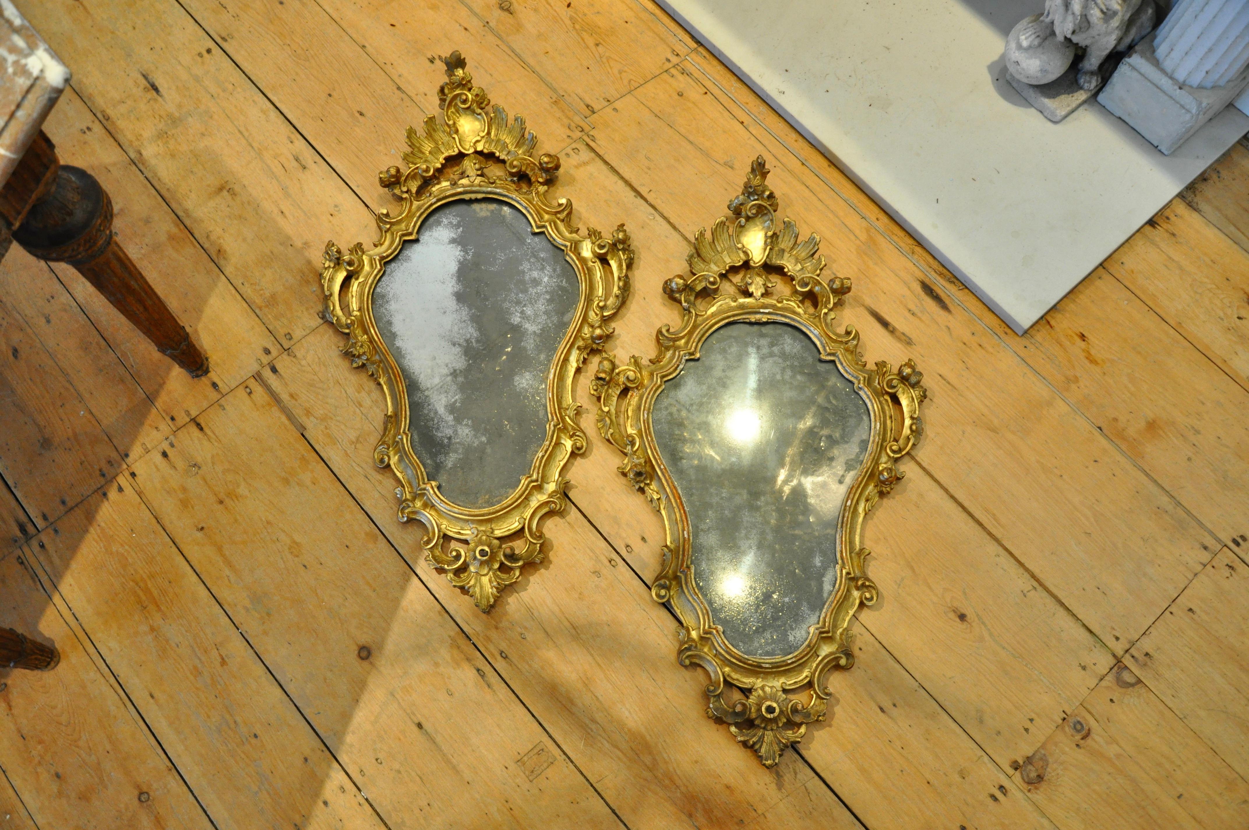 Pair of Italian 18th century gilt mirrors with original glass and original gilding.