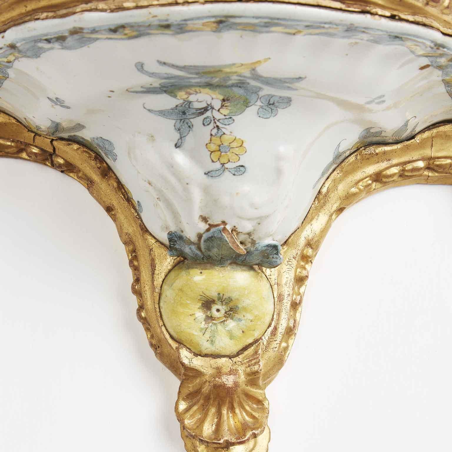 Delightful and unique pair of Baroque carved and gilded wall brackets realized with a white and green hand-painted majolica demi tureen lid of a Southern Italy manufacture Cerreto Sannita of the 18th century.

The ancient maiolica shows a fine