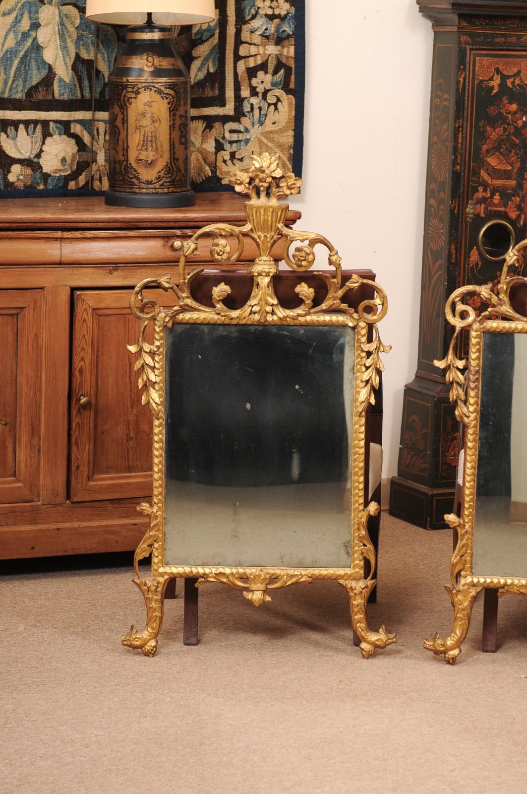 Coppia di specchi in legno dorato del XVIII secolo con dettagli di delfini e cesti di fiori