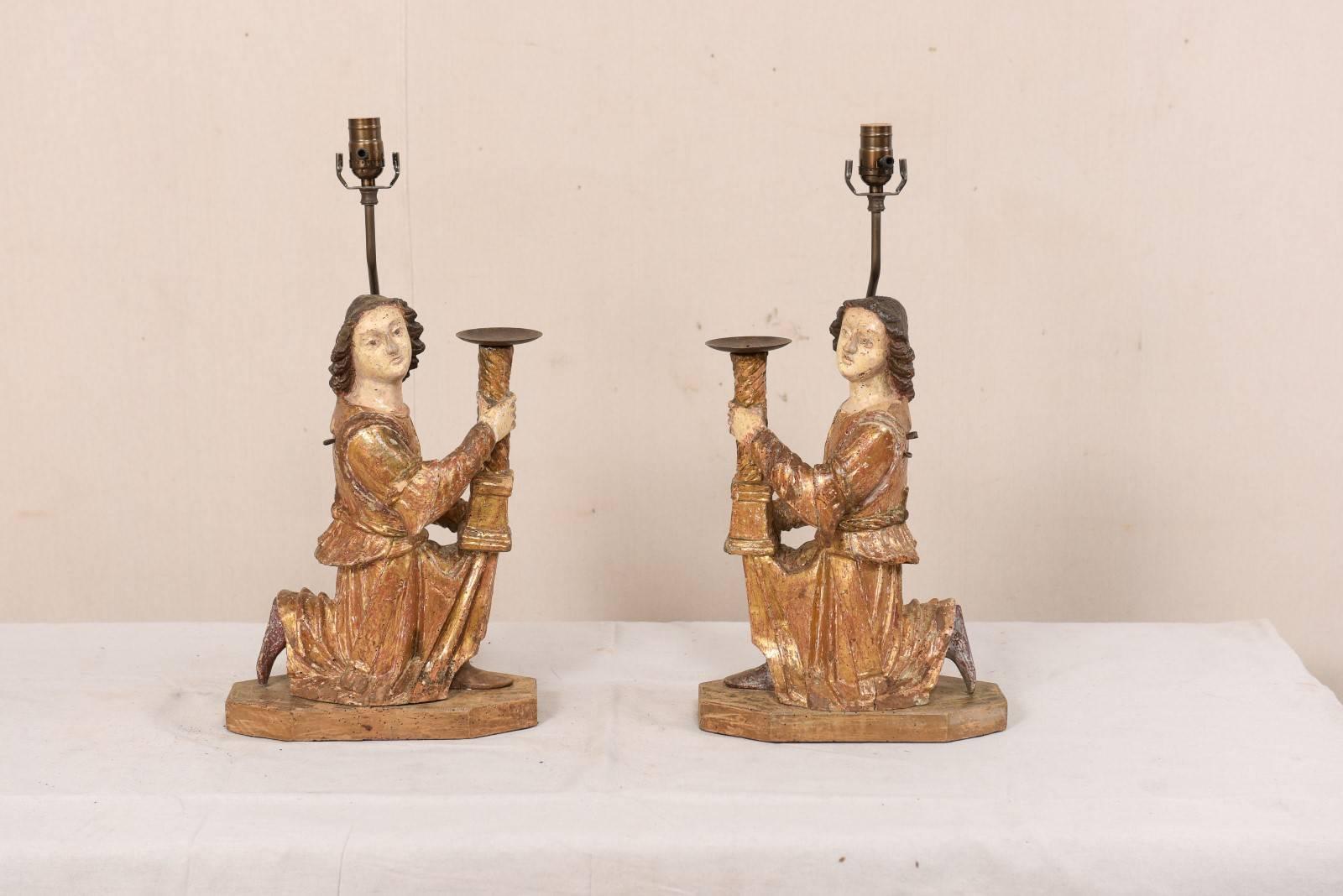 A pair of Italian 18th century figurative hand-carved candlestick table lamps. This exquisite pair of table lamps have been fashioned from a pair of 18th century hand-carved figurines from Sienna, Italy. The alter figures, with their gilded robes,