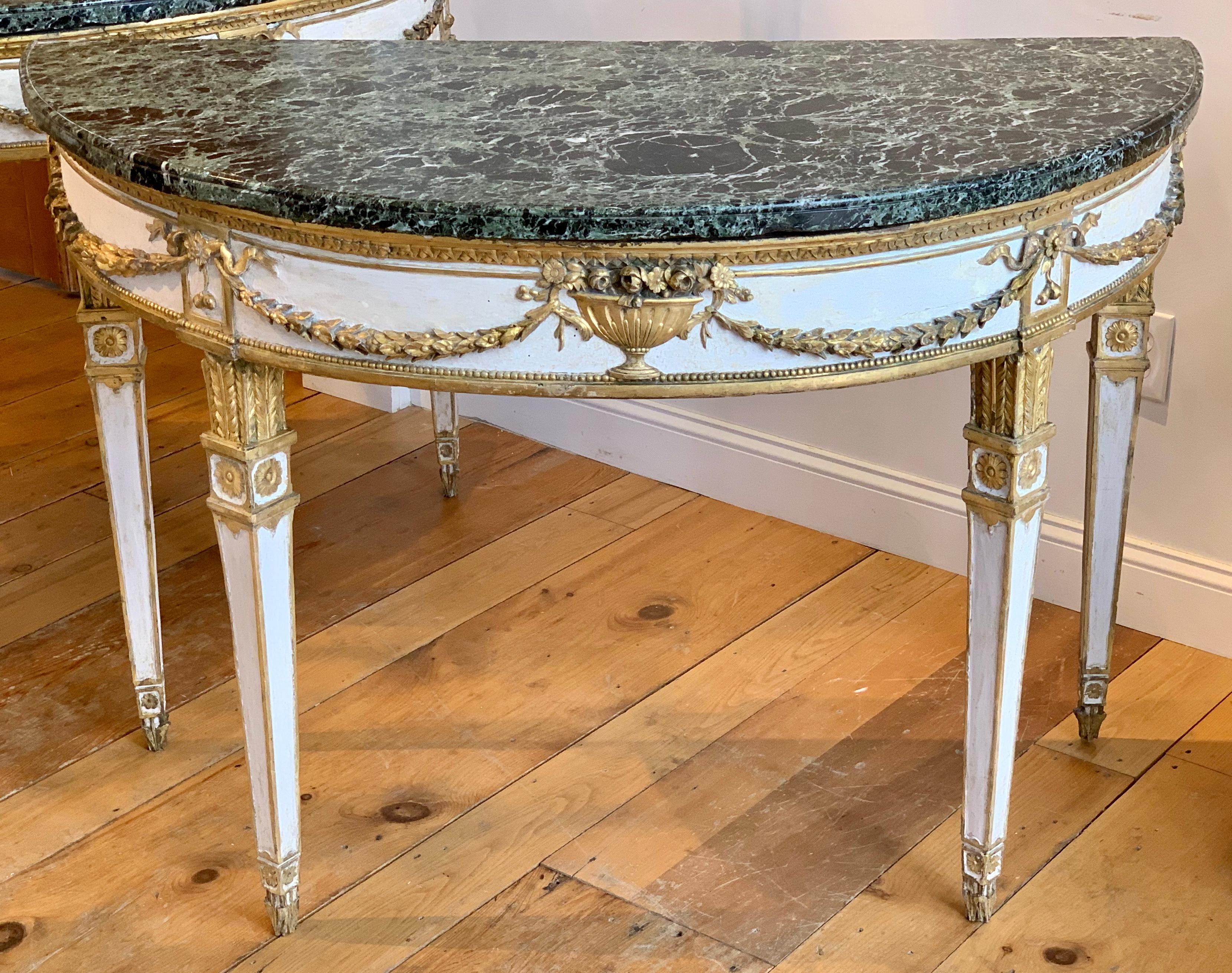 Pair of 18th Century Italian Neoclassical Demi-lune Console Tables.  Original Marble Tops.  All Carved and Parcel Gilt Wood.  Original recovered gilding.  Original surface recovered.  Realistically carved wood laurel swags, ribboned hanging fruit on