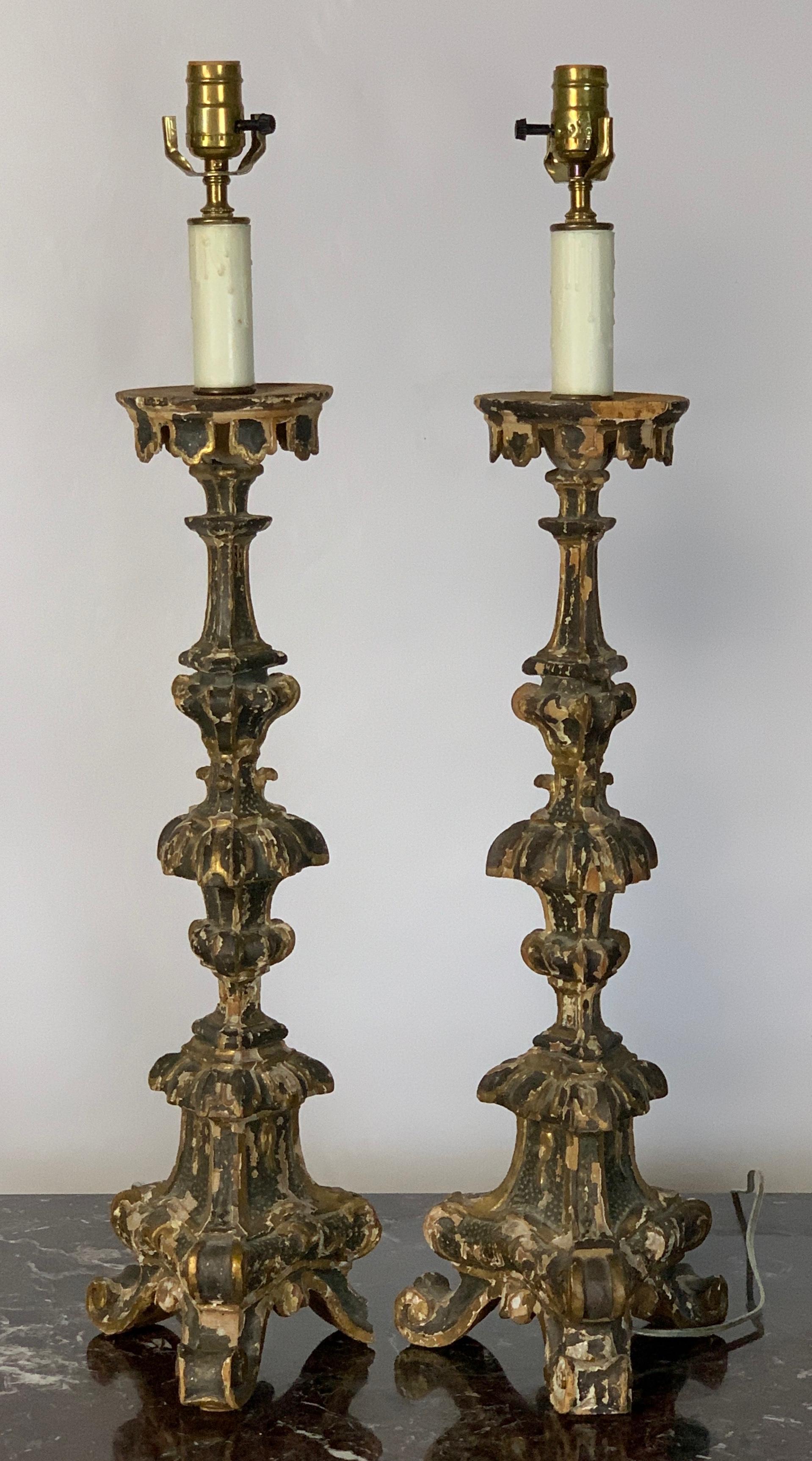 A fine pair of elaborately carved, painted and gilded 18th century Italian pricket candlesticks fashioned into table lamps.
