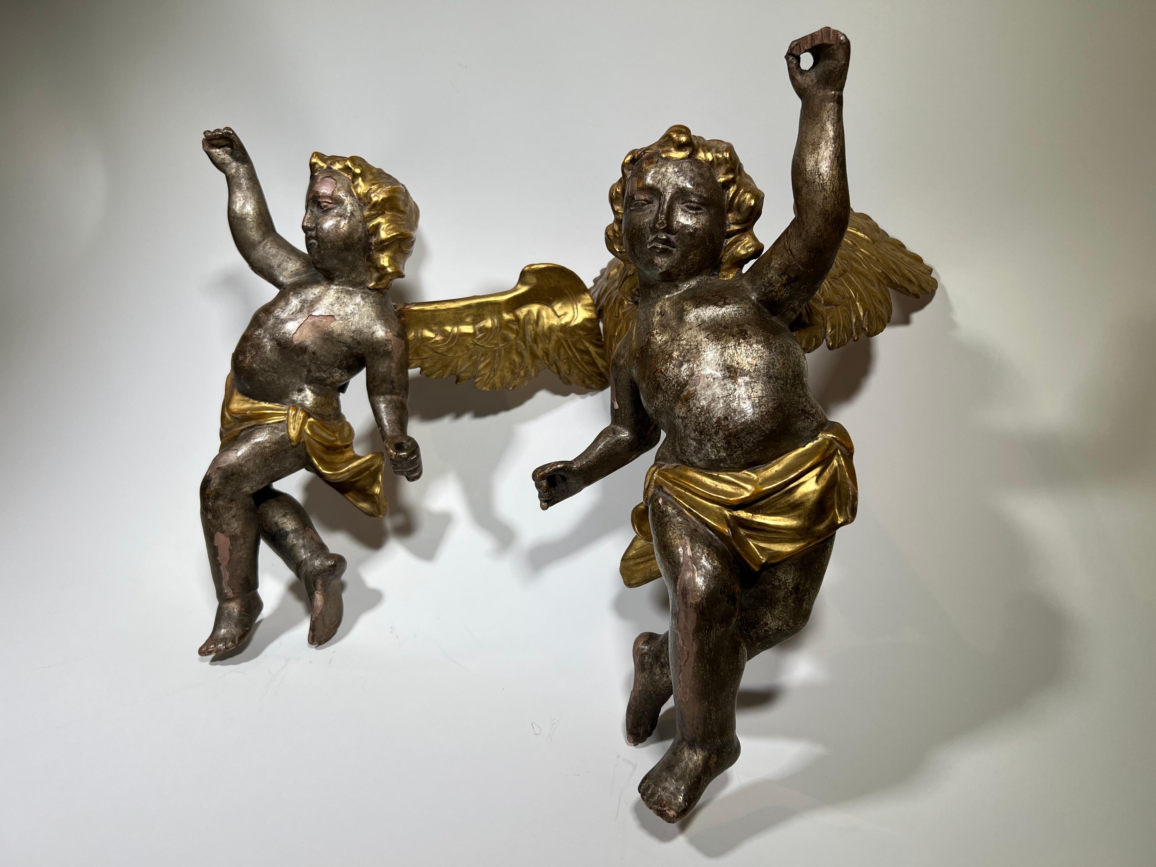 A delightful pair of 18th century Italian puttini or cherubs in giltwood. Wonderfully carved with delicate features - lending this pair elegance and charm.
