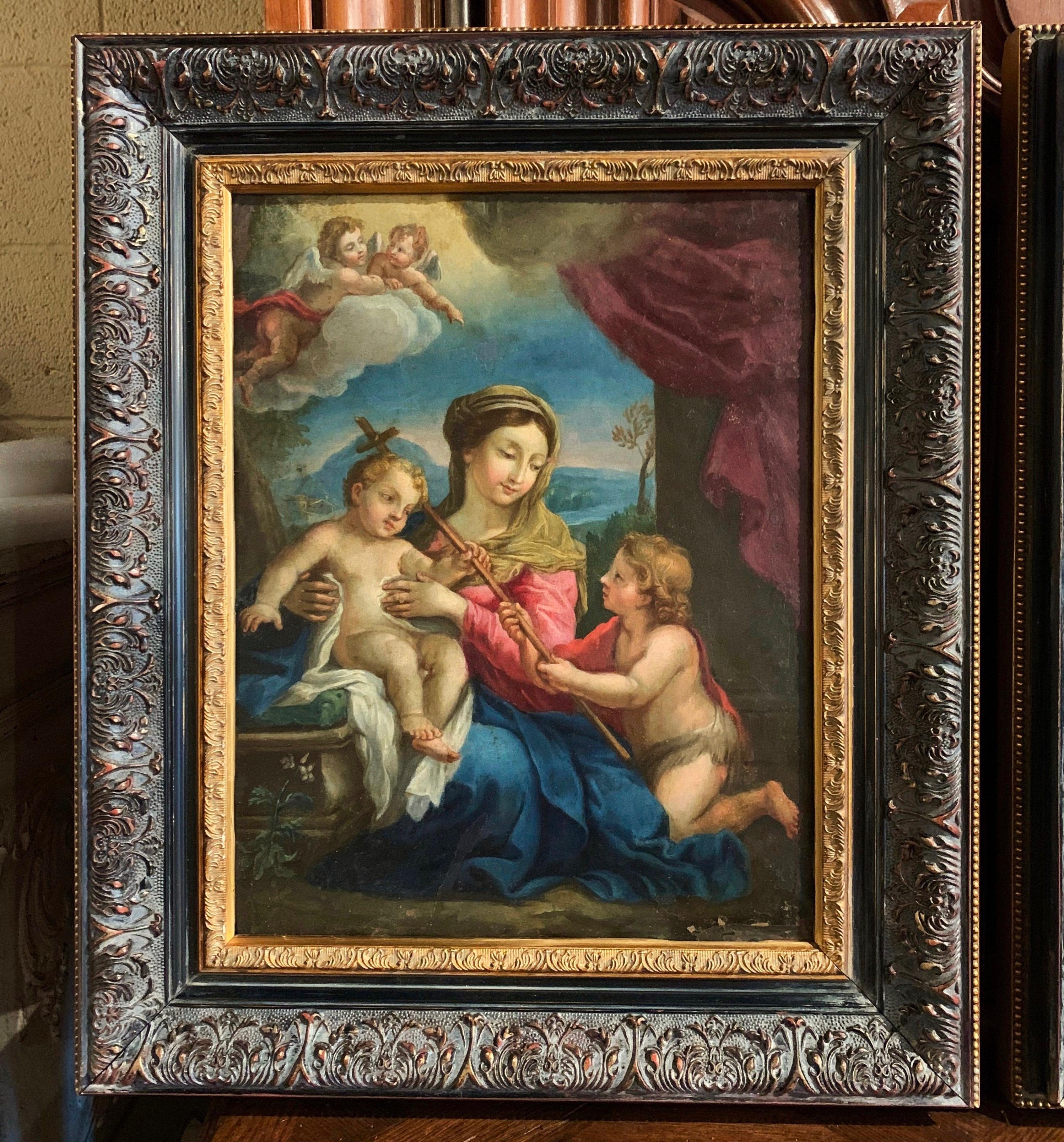 Created in Italy circa 1780 and set in carved blackened and gilt frames, the pair of antique religious artworks are hand painted on copper. One painting depicts a nativity scene of our Lord with Saint Mary, Joseph and attended with angels and