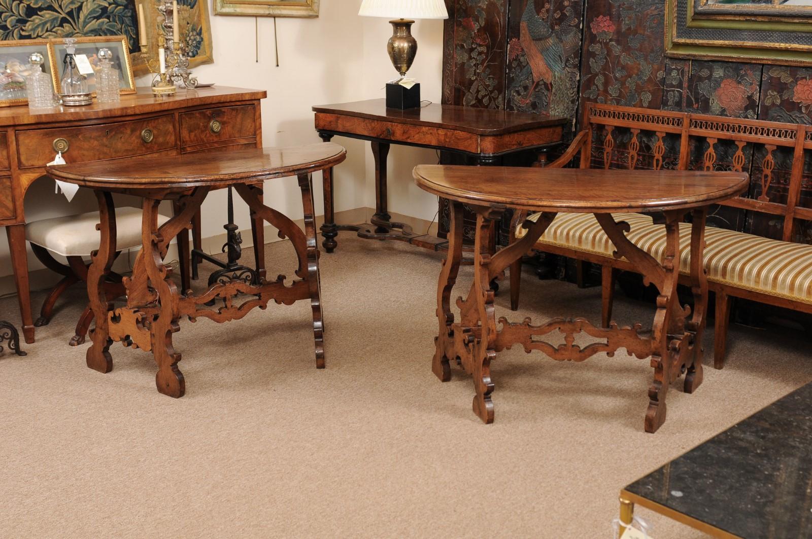The pair of Italian 18th century Italian walnut demilune console tables with lyre shaped legs.