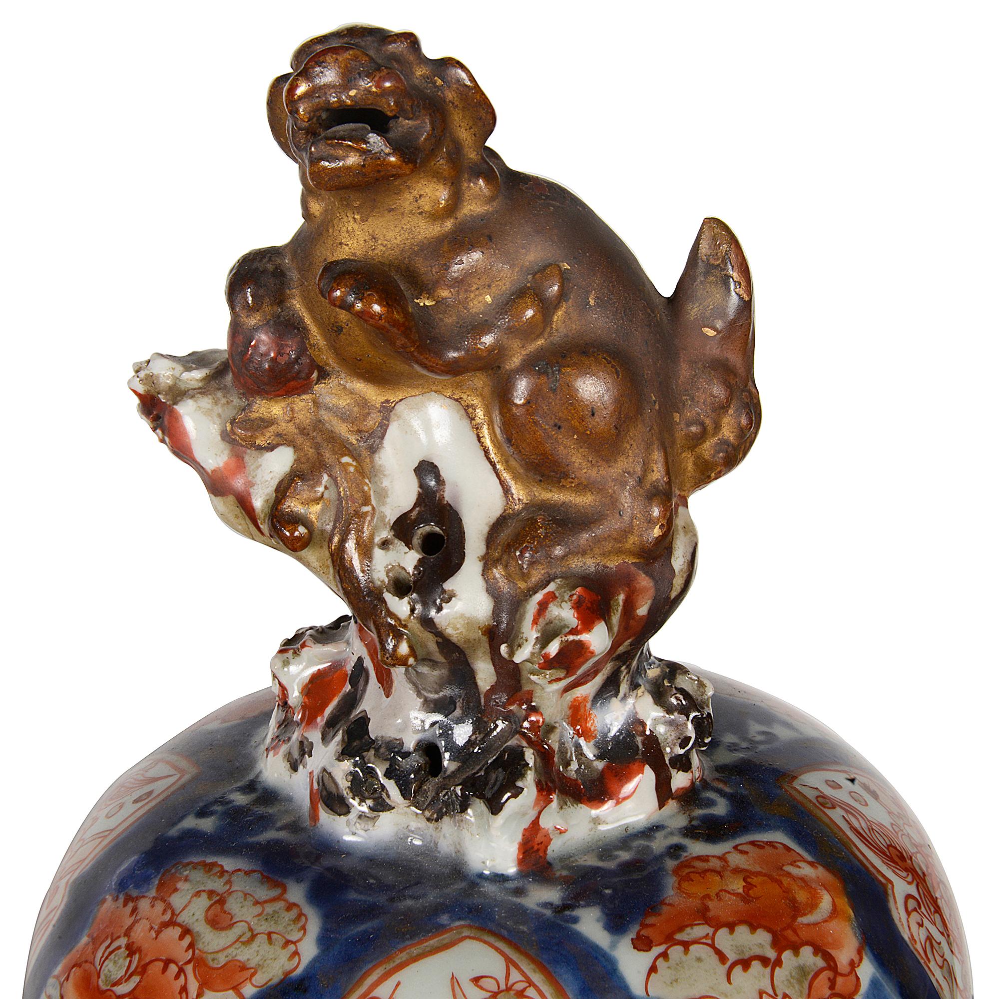 A very good quality pair of late 18th century Japanese lidded Imari vases. Each with Dog of foo gilded finials. Blue ground scrolling decoration, with inset hand painted panels depicting exotic peacocks, flowers and foo dogs.
 