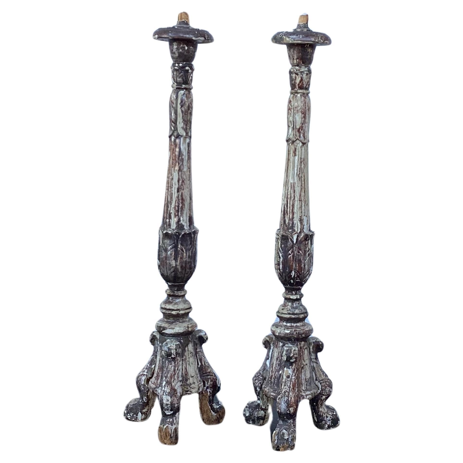 Very tall pair of 18th century Italian Baroque candlesticks. Exquisitely hand carved with wonderfully distressed silver gilt patina, resting on a scrolled tripod base. 