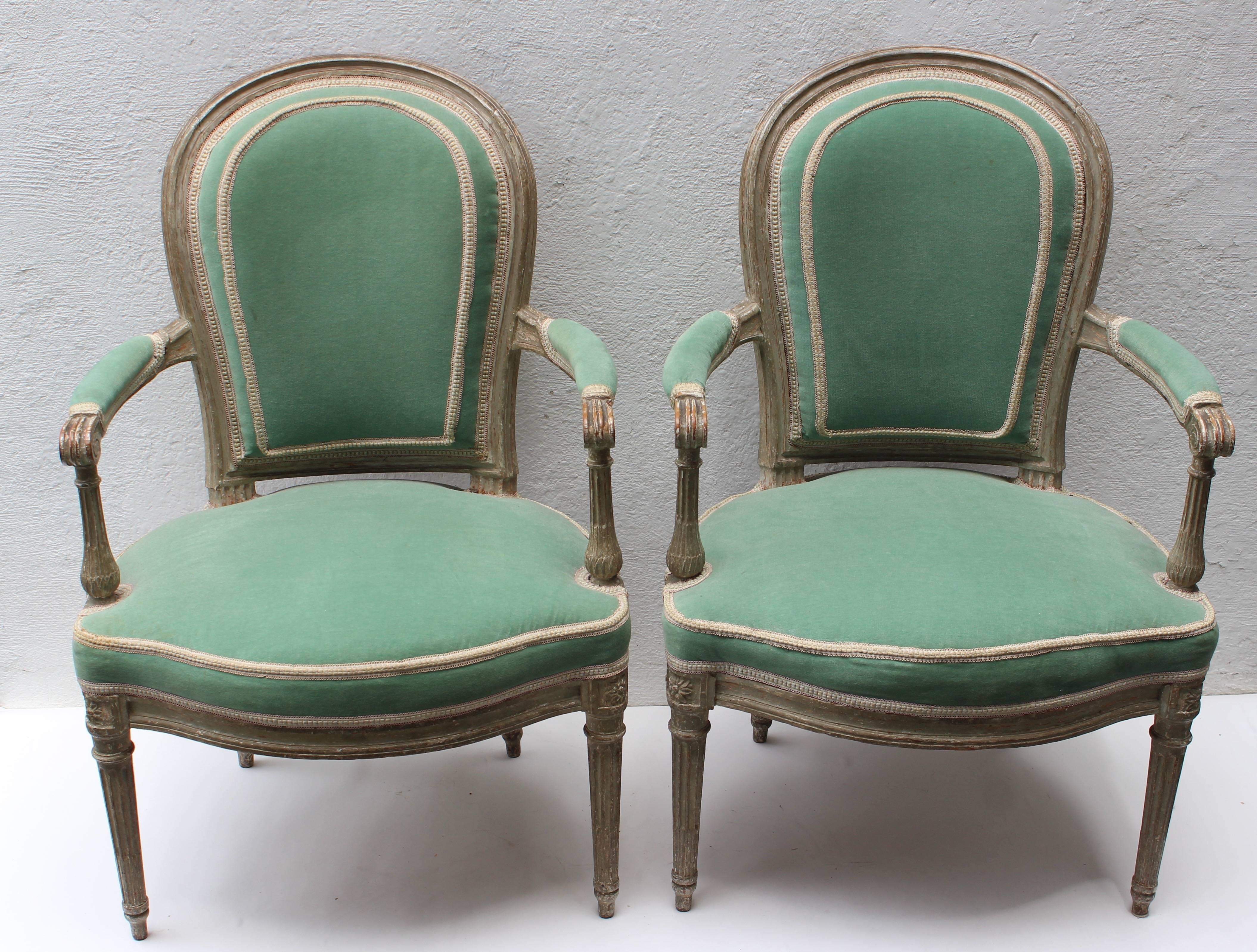 Pair of Louis XVI painted white fauteuils en cabriolet attributed to Georges Jacob (1739-1814) circa 1780.

With round channel-moulded backrest issuing straight scrolled arms with manchettes above serpentine U-form seat, the conforming seatrail