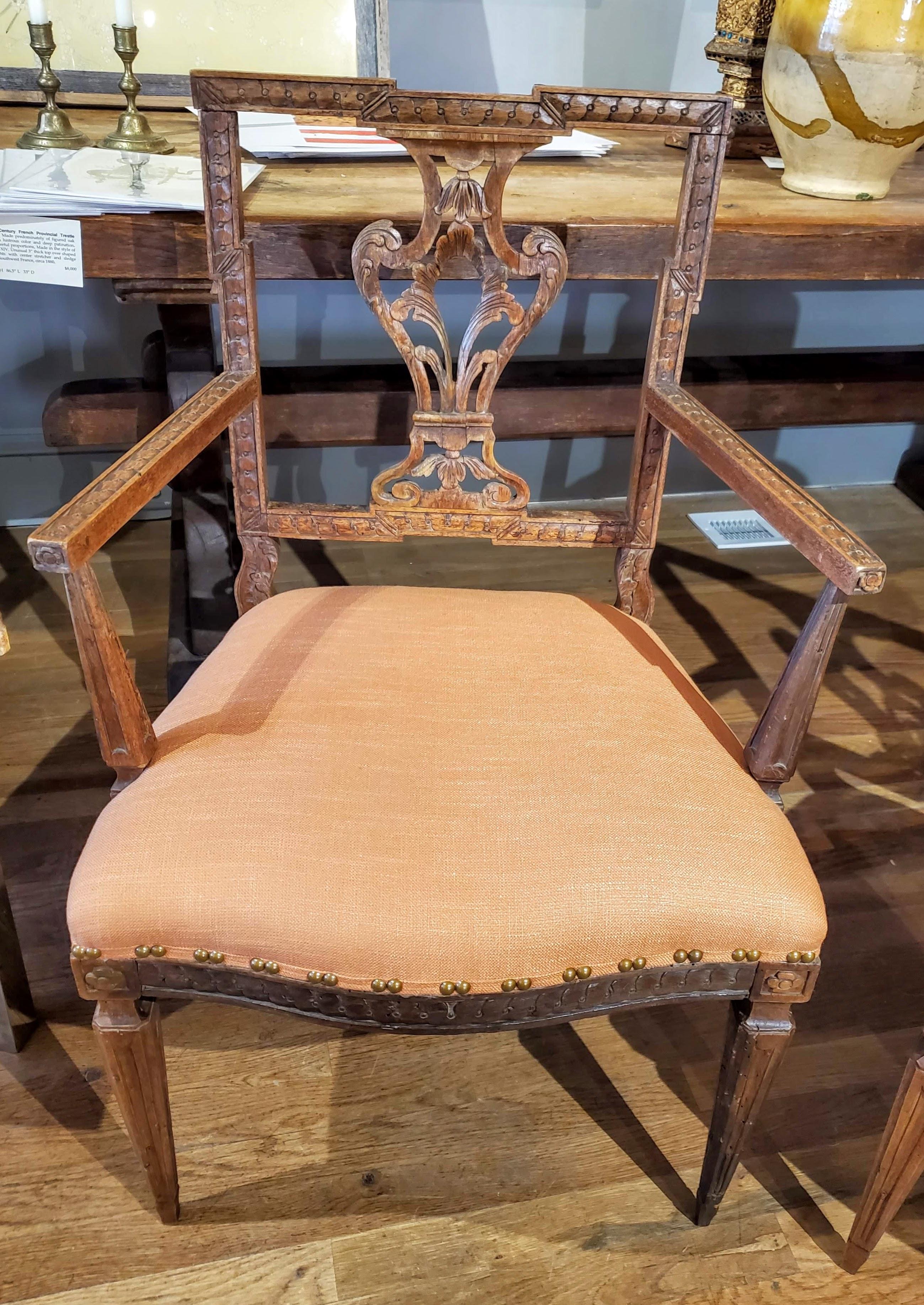 A lovely pair of 18th century Louis XVI French provincial armchairs with remarkable Italian influence. Made of Circassian walnut with intricate carved decoration over straight tapering legs. Good color and rich patination. Newly reupholstered in