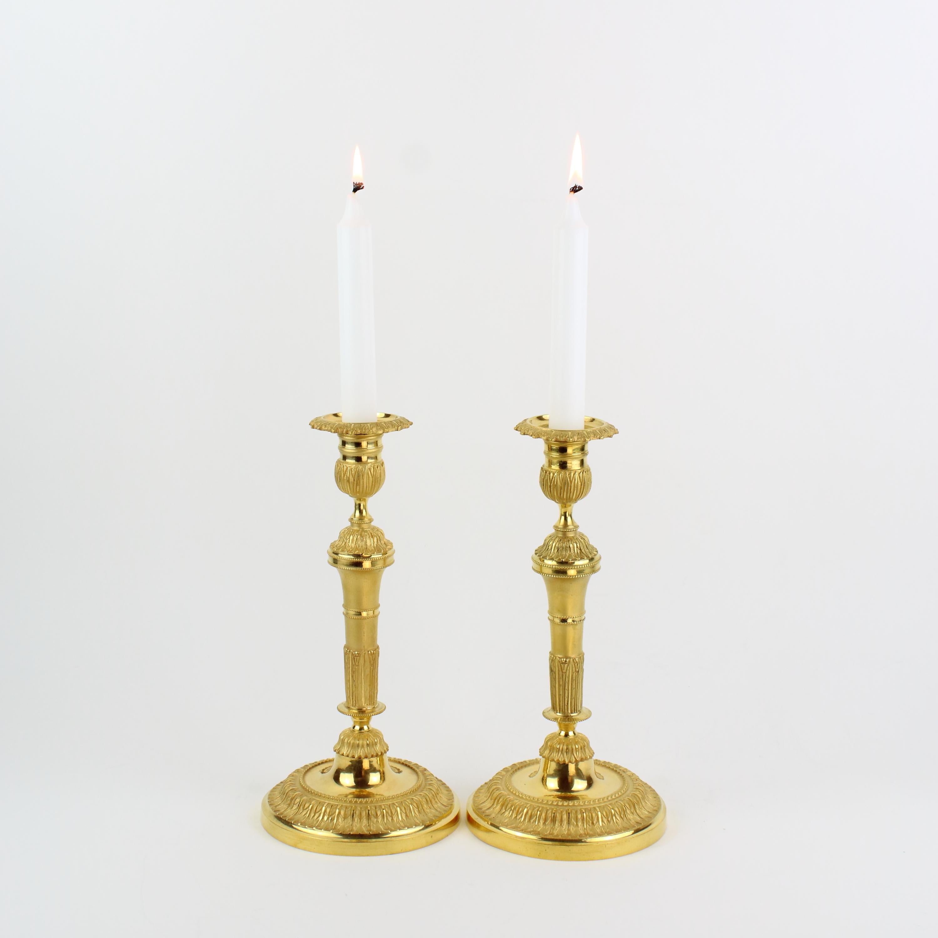 Pair of 18th century Louis XVI neoclassical gilt bronze candlesticks

The tapering stem with matte and polished gilt bronze parts decorated with lanceolate leaf foliage standing on a round and slightly domed foot showing the same foliage
