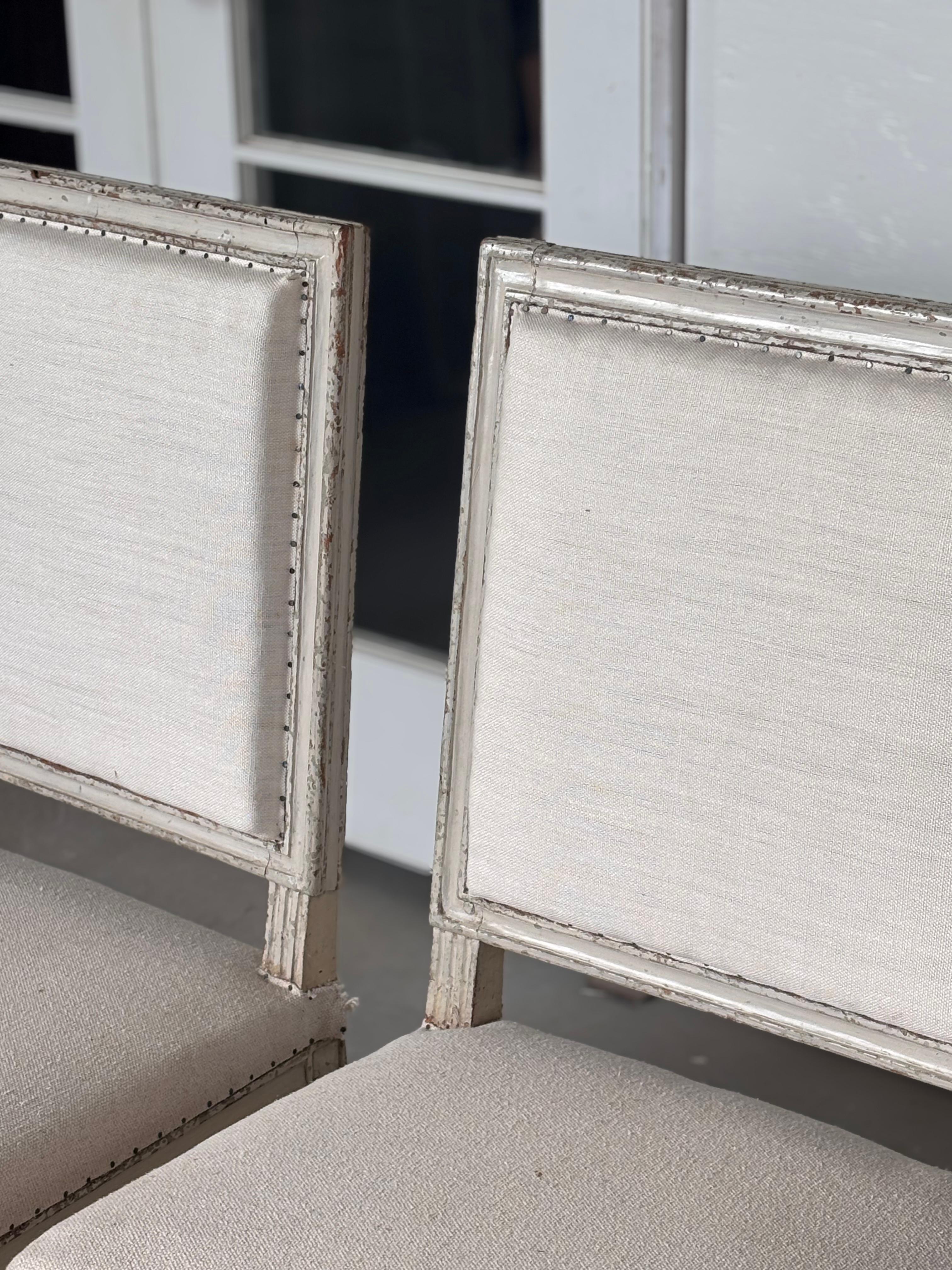 Élevez votre intérieur avec cette exquise paire de chaises Louis XVI du XVIIIe siècle, un mélange magistral d'élégance néoclassique et d'artisanat intemporel. Sculptées à la main dans du bois massif et recouvertes d'une douce peinture blanche
