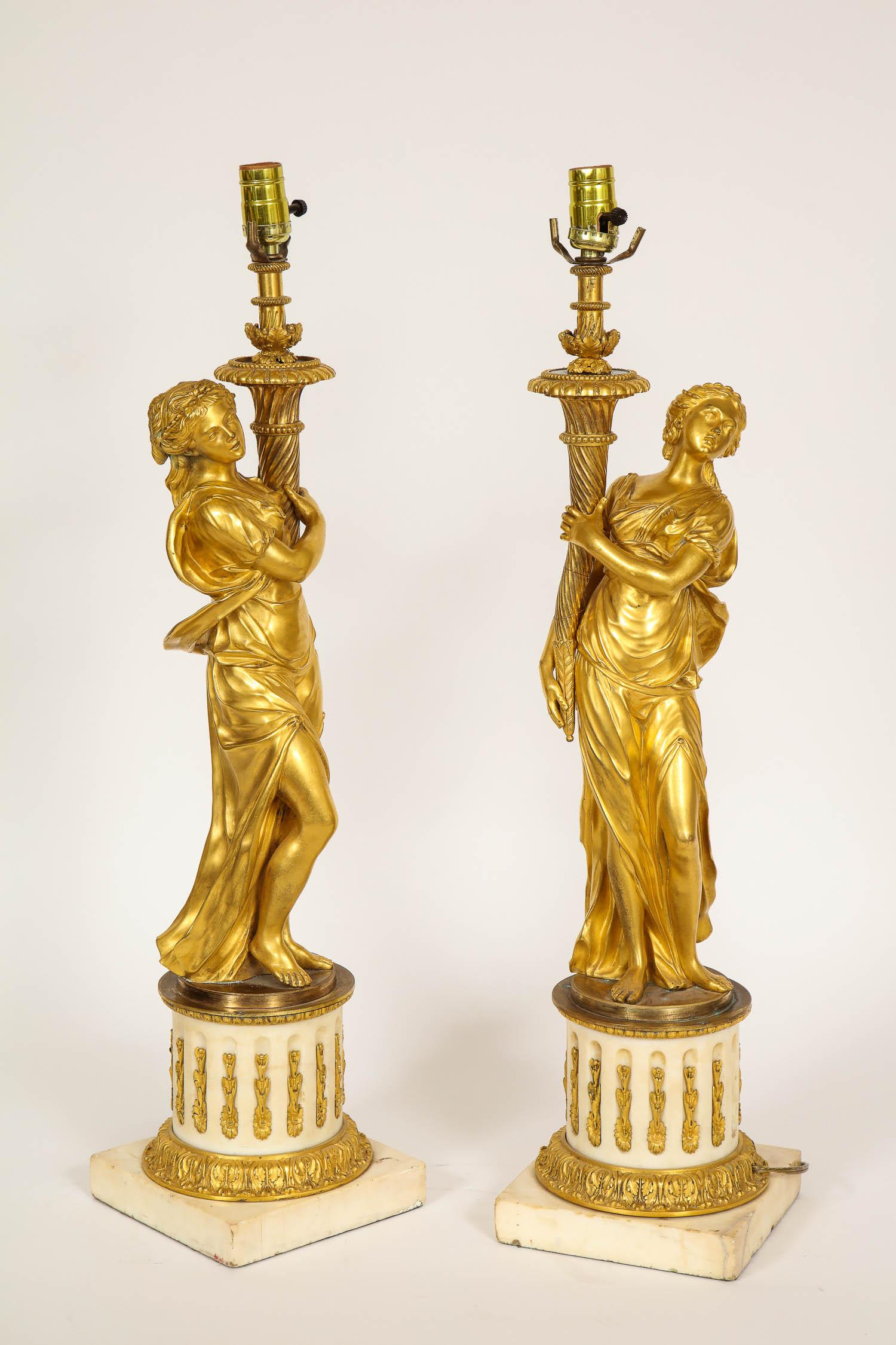 Ein prächtiges Paar antiker französischer Figuren aus vergoldeter Bronze und weißem Carrara-Marmor aus der Louis-XVI-Periode (18. Jahrhundert), die als Lampen montiert sind. Dieses prächtige Paar vergoldeter Bronzefiguren stellt zwei schöne