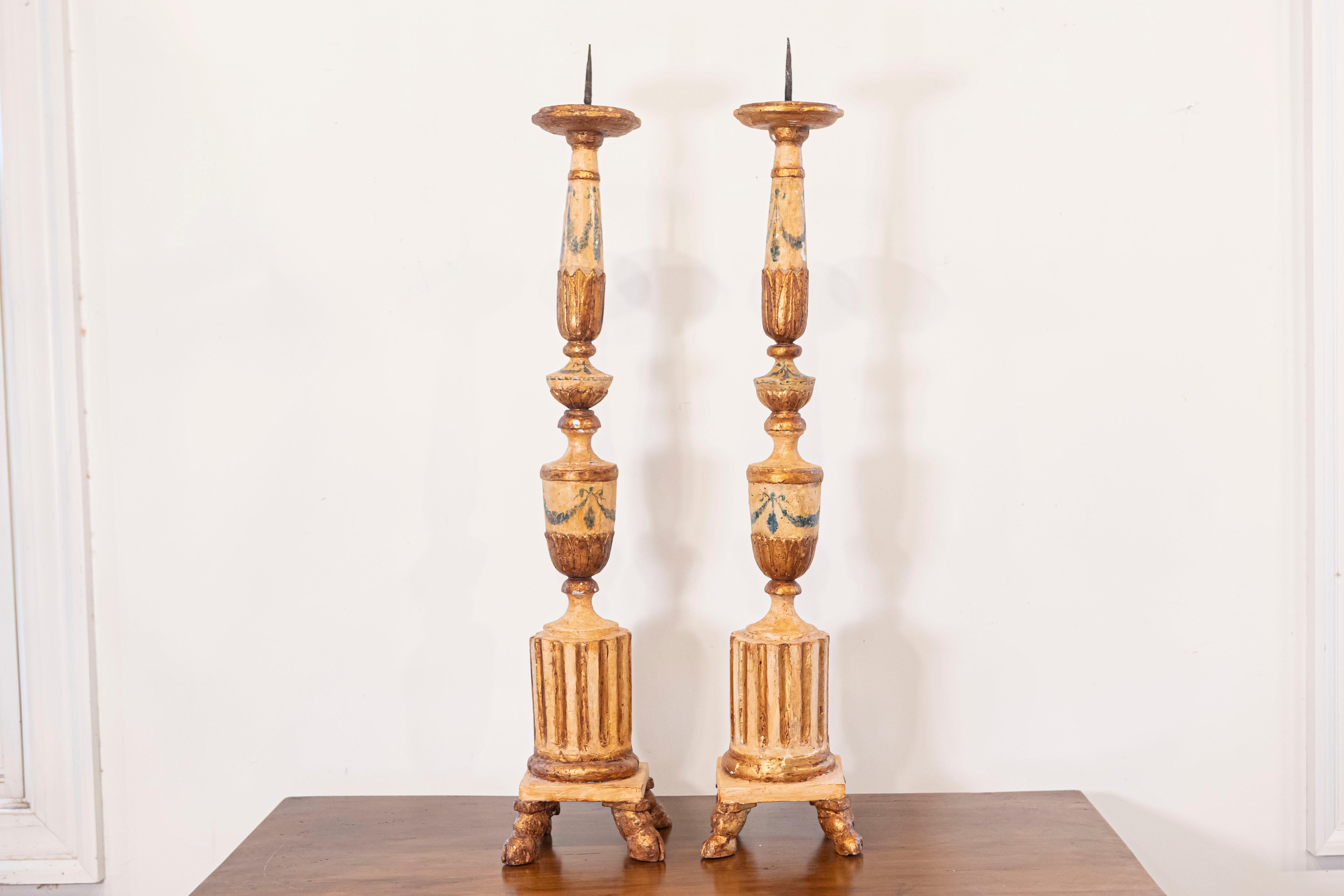 Paire de chandeliers italiens néoclassiques peints et dorés du XVIIIe siècle, avec des motifs cannelés et des pieds en sabot. Créée en Italie au cours des dernières années du XVIIIe siècle, cette paire de chandeliers présente un corps peint rehaussé