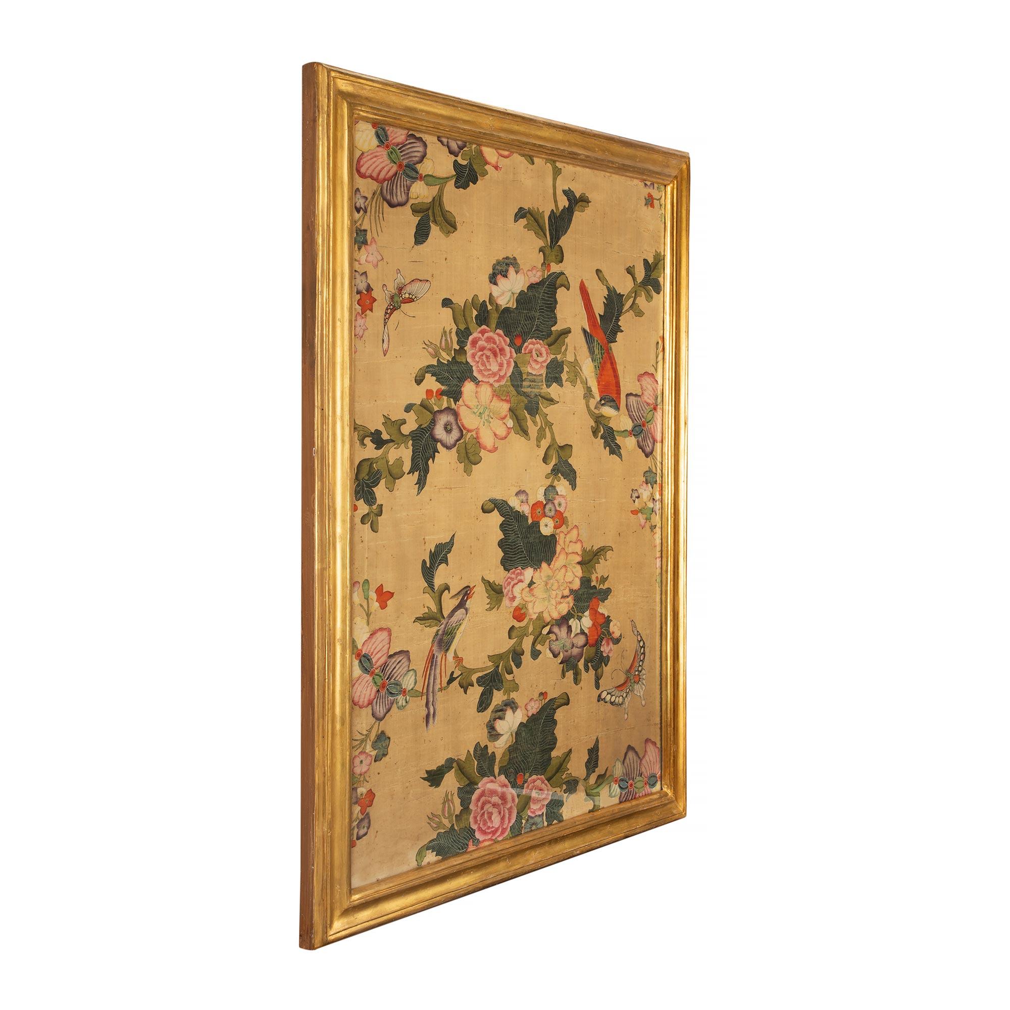 A fine and most elegant pair of 18th century panels of hand painted Asian silk of colorful branches filled with exotic flowers amidst birds and butterflies. The panels are framed within Italian 18th century rectangular mottled frames from the