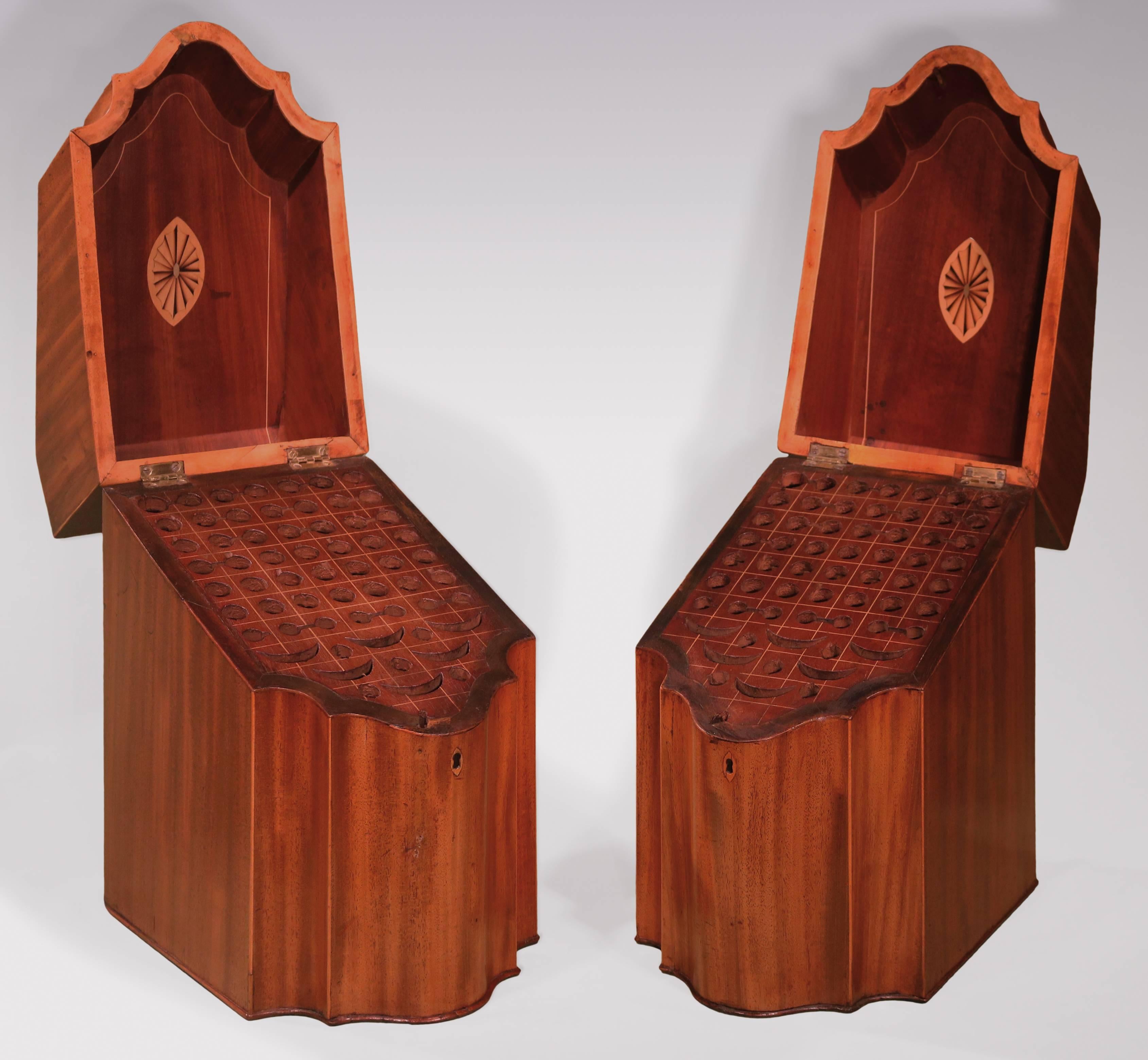 A pair of late 18th century Sheraton period faded and figured mahogany serpentine fronted cutlery boxes, having boxwood strung and tulipwood crossbanded tops with central oval urn and flower paneled inlays, retaining original interiors.