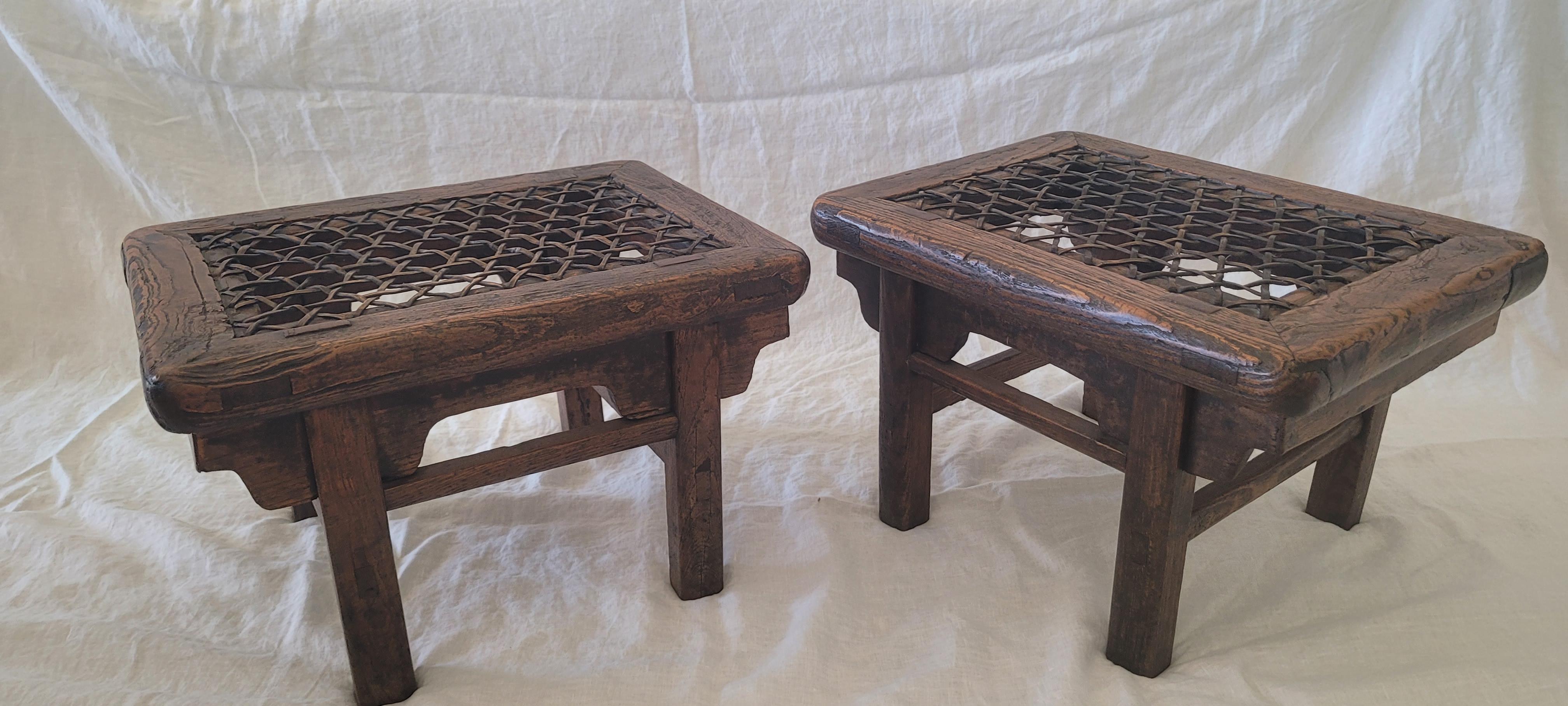A pair of rectangular shape stools. The seat is made of woven cowhide framed in mitered mortise and tenon members. The legs are recessed and connected to the seat in elongated bridle joints. The aprons and spandrels are simple and undecorated. A