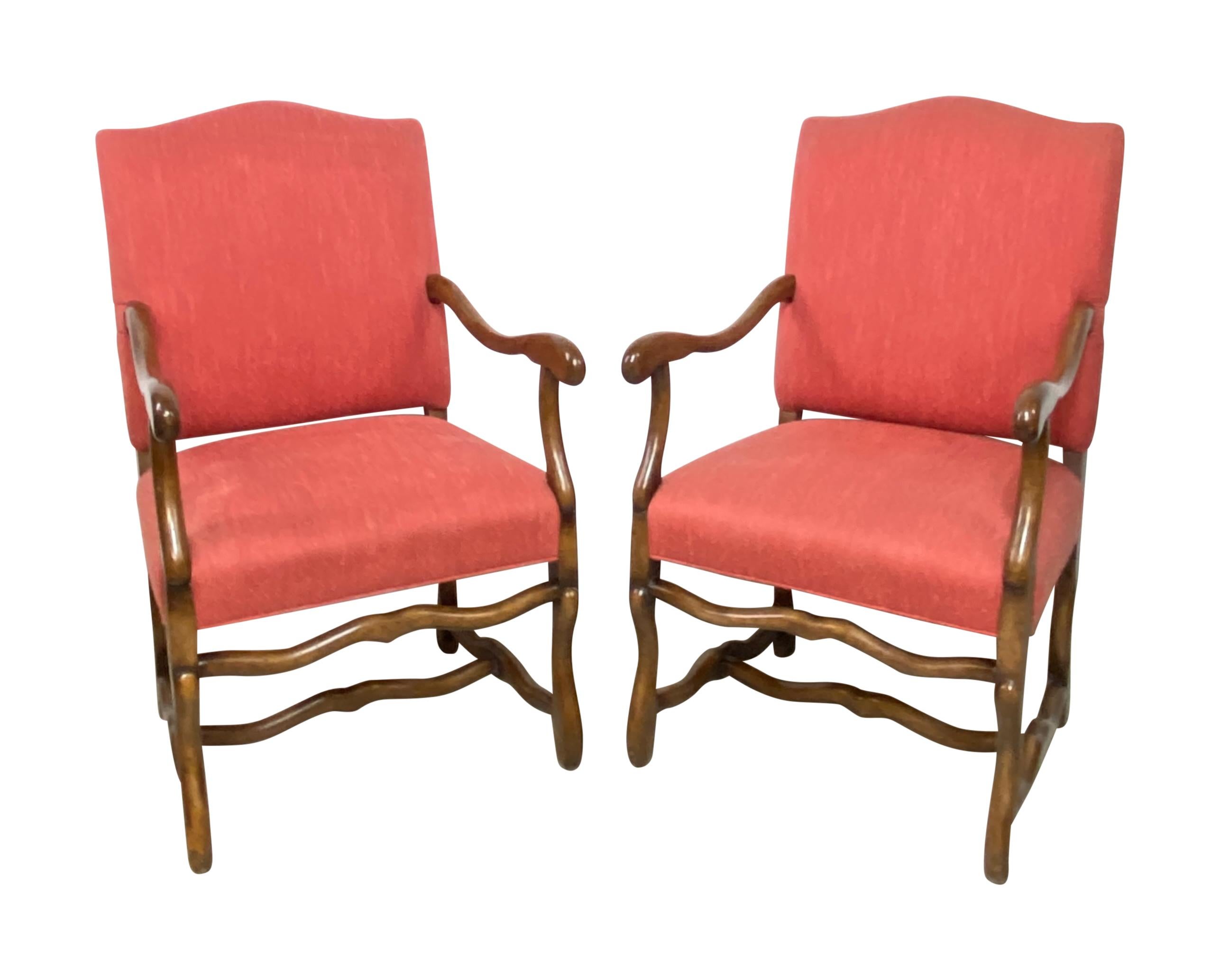 A pair of quality bench made walnut armchairs. Made in the early 20th century in the same manor as period chairs but with spring seats. 
Old nicely distressed finish. 
Upholstery is a salmon colored wool Herringbone tweed in fair condition. Buyer
