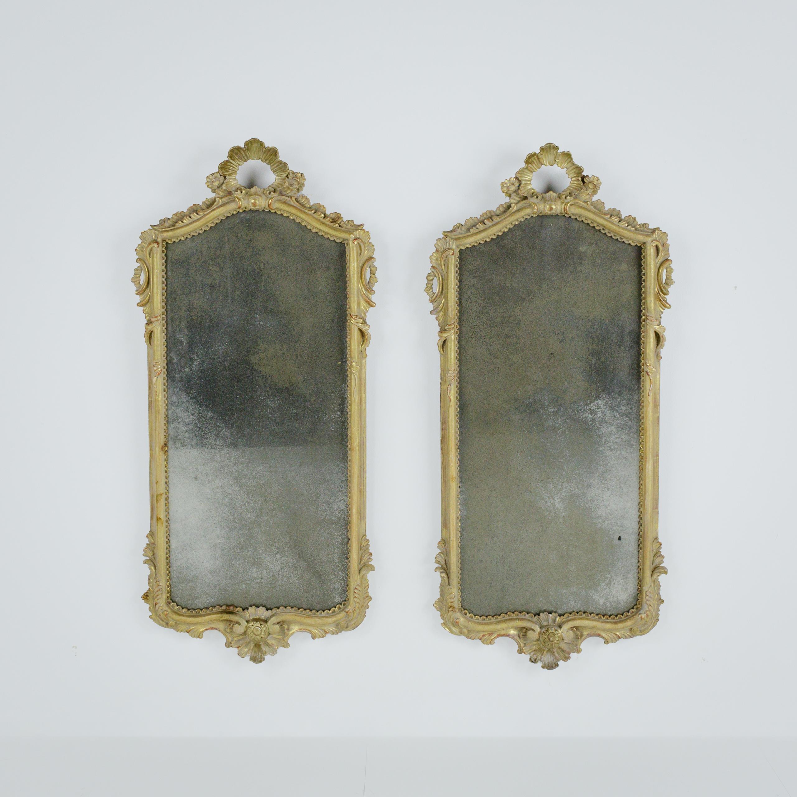 Paire de miroirs à encadrement doré de style XVIIIe siècle.

Cette paire de miroirs raffinés, de style XVIIIe siècle, présente des crêtes légèrement arquées, des rinceaux feuillagés et des motifs floraux décorés de façon complexe, ainsi qu'un