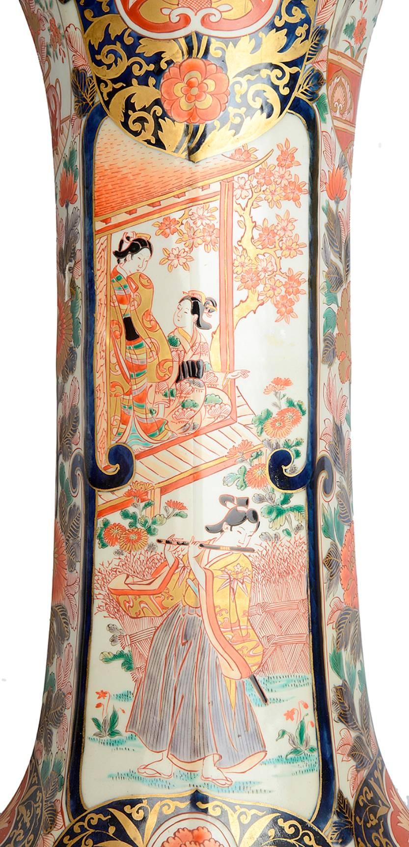 Une grande et impressionnante paire de vases à déversement de style Imari japonais du 18ème siècle. Chacune avec les couleurs classiques Imari de bleus et d'oranges. Le sol est orné de fleurs, de rinceaux, de motifs et de dragons parmi les nuages.
