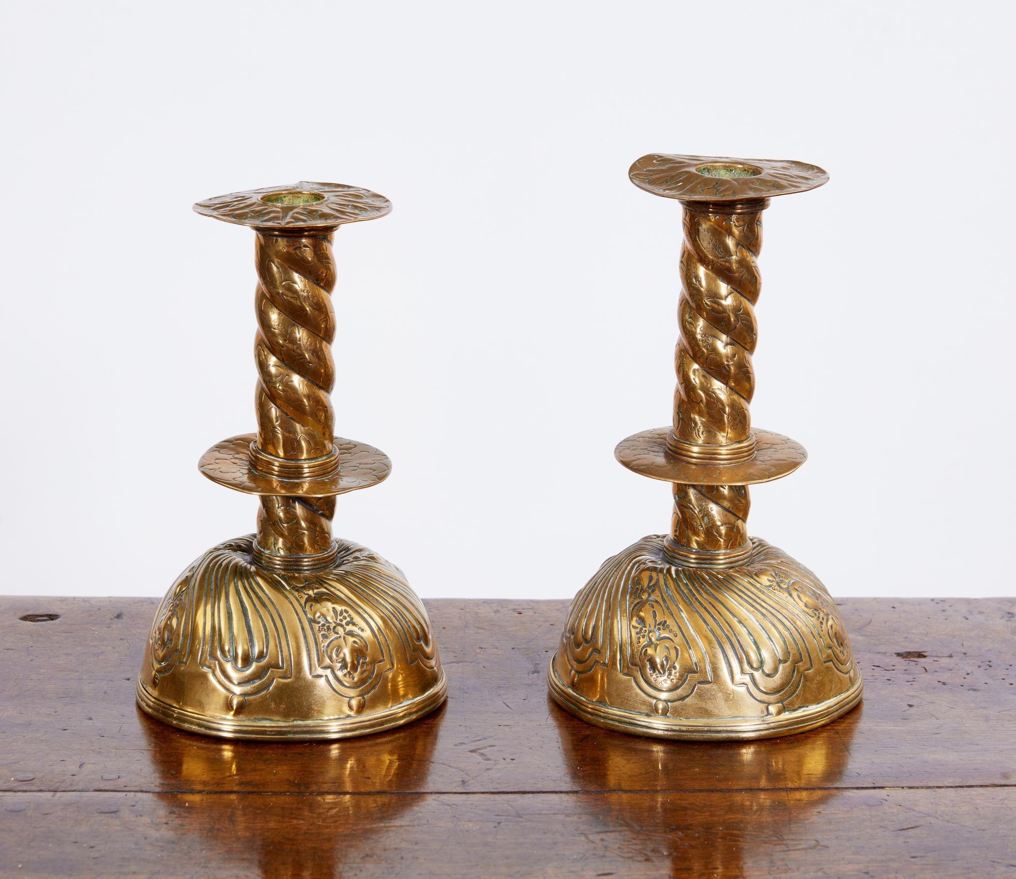 Good pair of 18th Century Swedish baroque hand hammered brass candlesticks with removable drip pan over barleytwist shafts with central drip collar, standing on bulbous bases having spiral floral decoration.