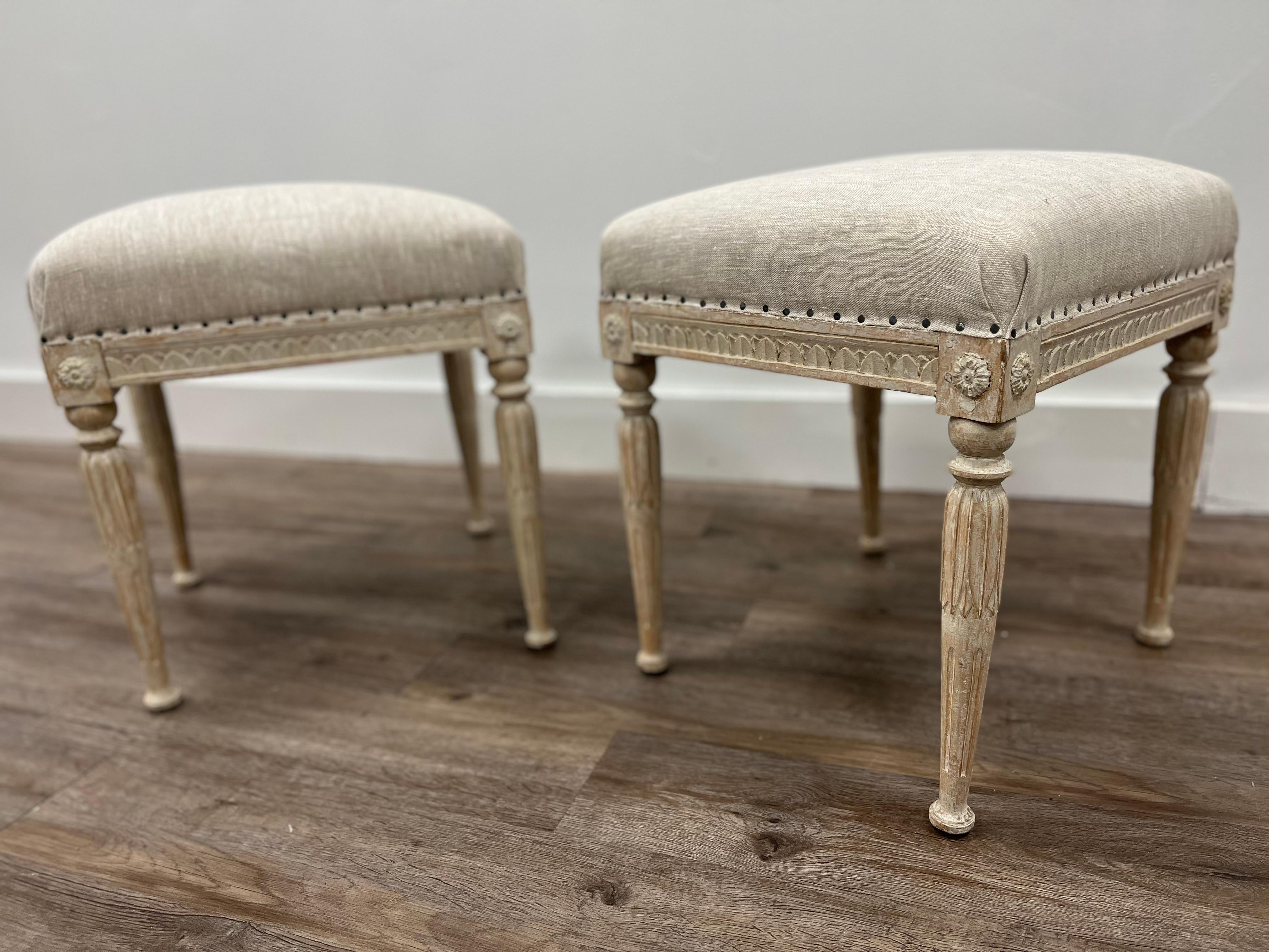A rare pair of Gustavian footstools with Stockholm chairmaker’s seal on both. Frames are decorated with upright leaf cut. The corners meet in decorative medallions. The legs are finished with over-collaring atop elongated vertical leaf cut and