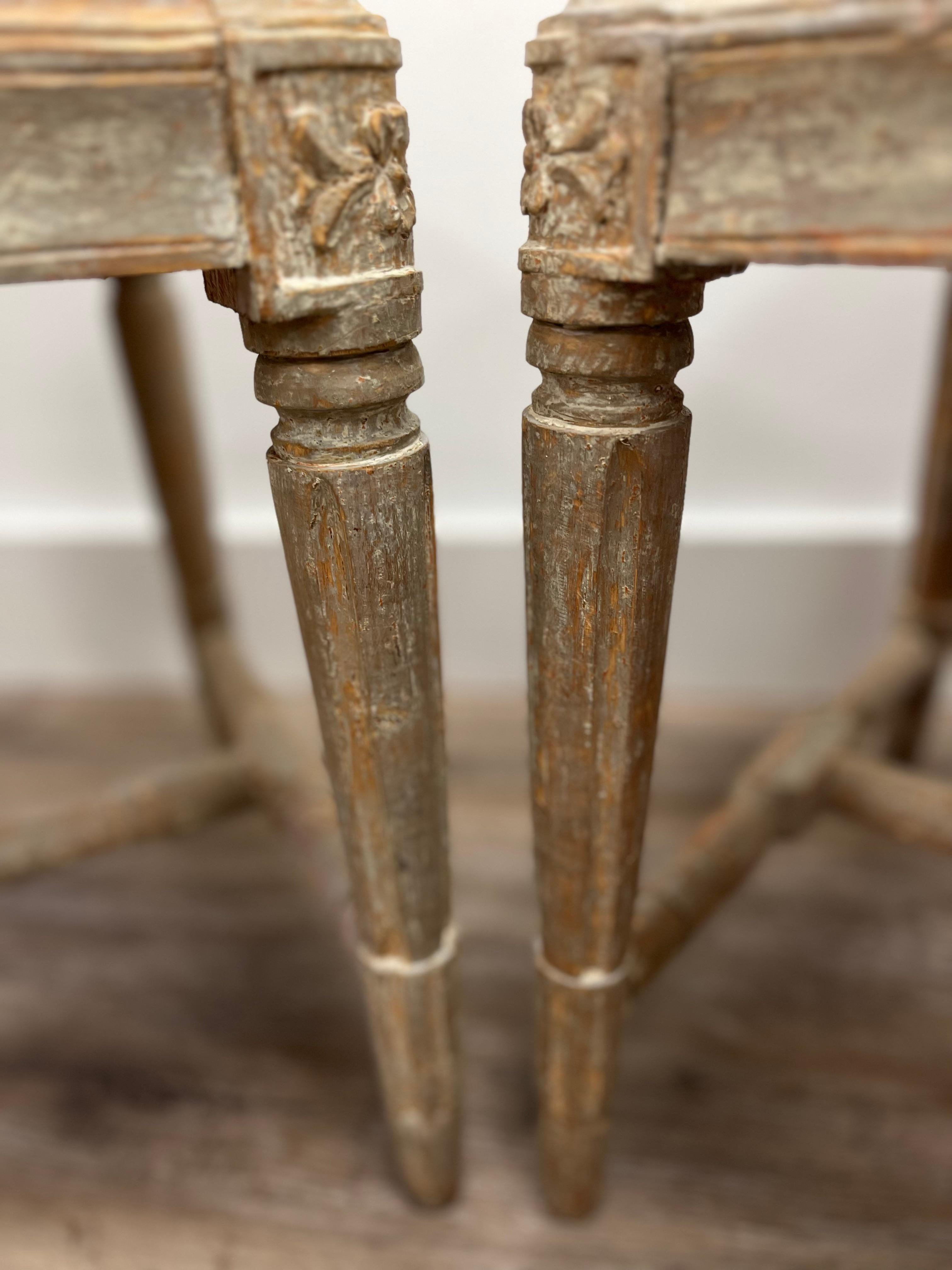 A pair of Swedish Gustavian footstools with rounded fleurons on the corners. The legs are turned, tapered and fluted. Supported by turned H-cross construction. This piece has been meticulously scraped to its original soft grey/blue color and