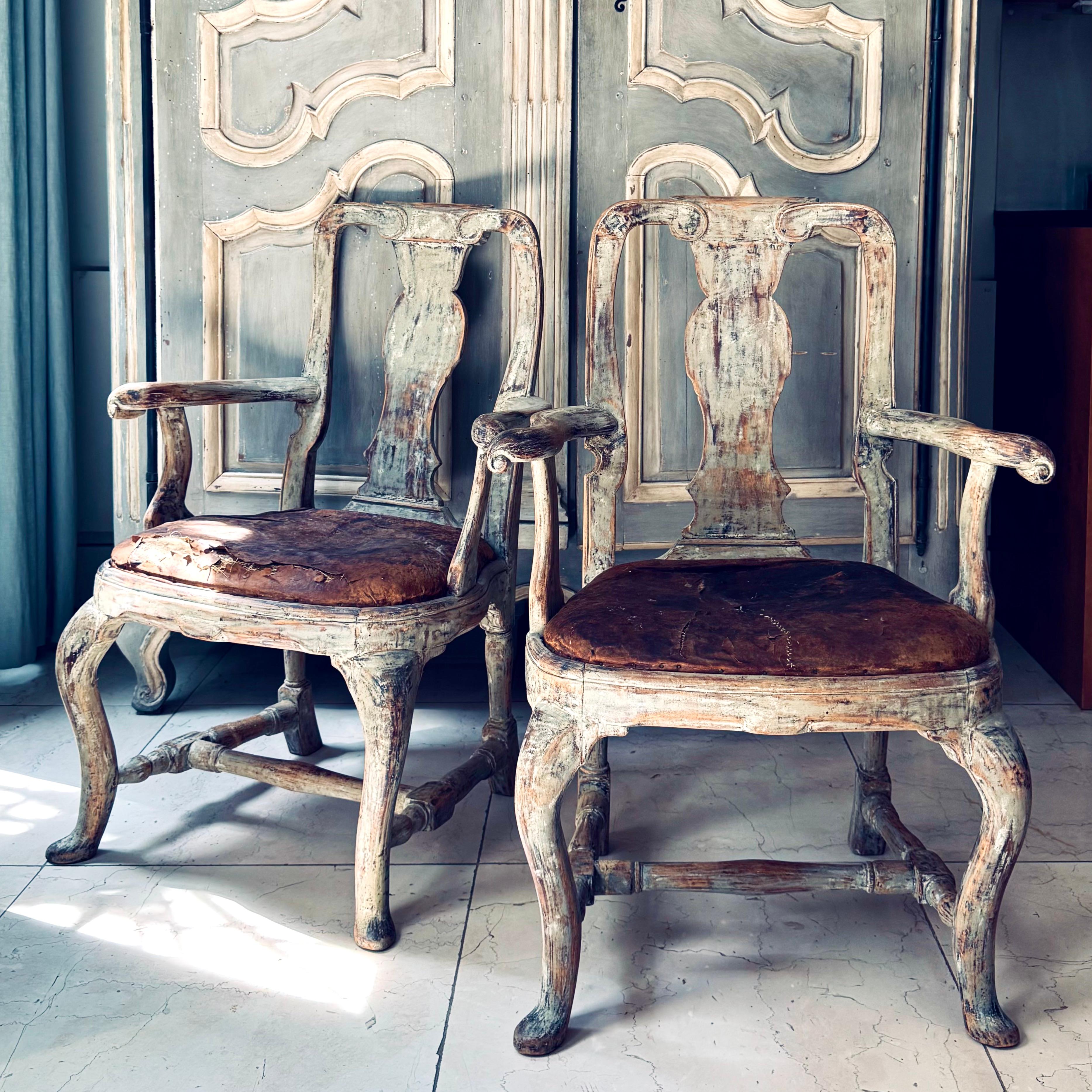 Paire de fauteuils rococo d'époque suédoise du XVIIIe siècle qui ont été grattés jusqu'à la plus grande partie de leur finition d'origine, le bois naturel apparaissant à travers. 
Cette paire présente des pieds cabriole sculptés avec un châssis en