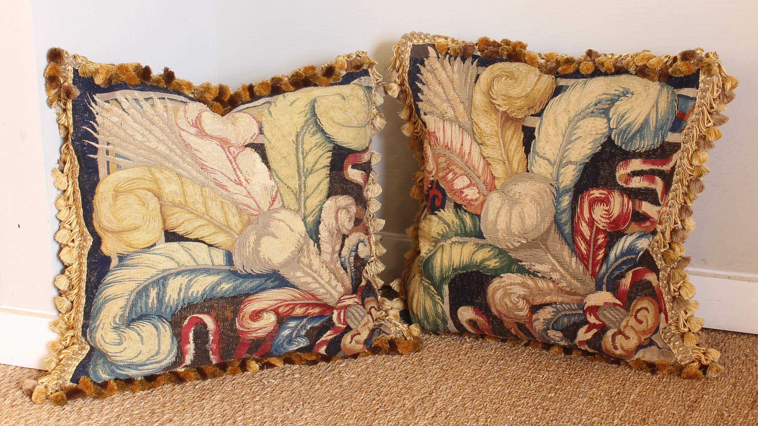 A pair of large down-filled pillows fashioned from a beautiful early 18th century. Flemish tapestry fragments depicting feathers in rich jewel tones.