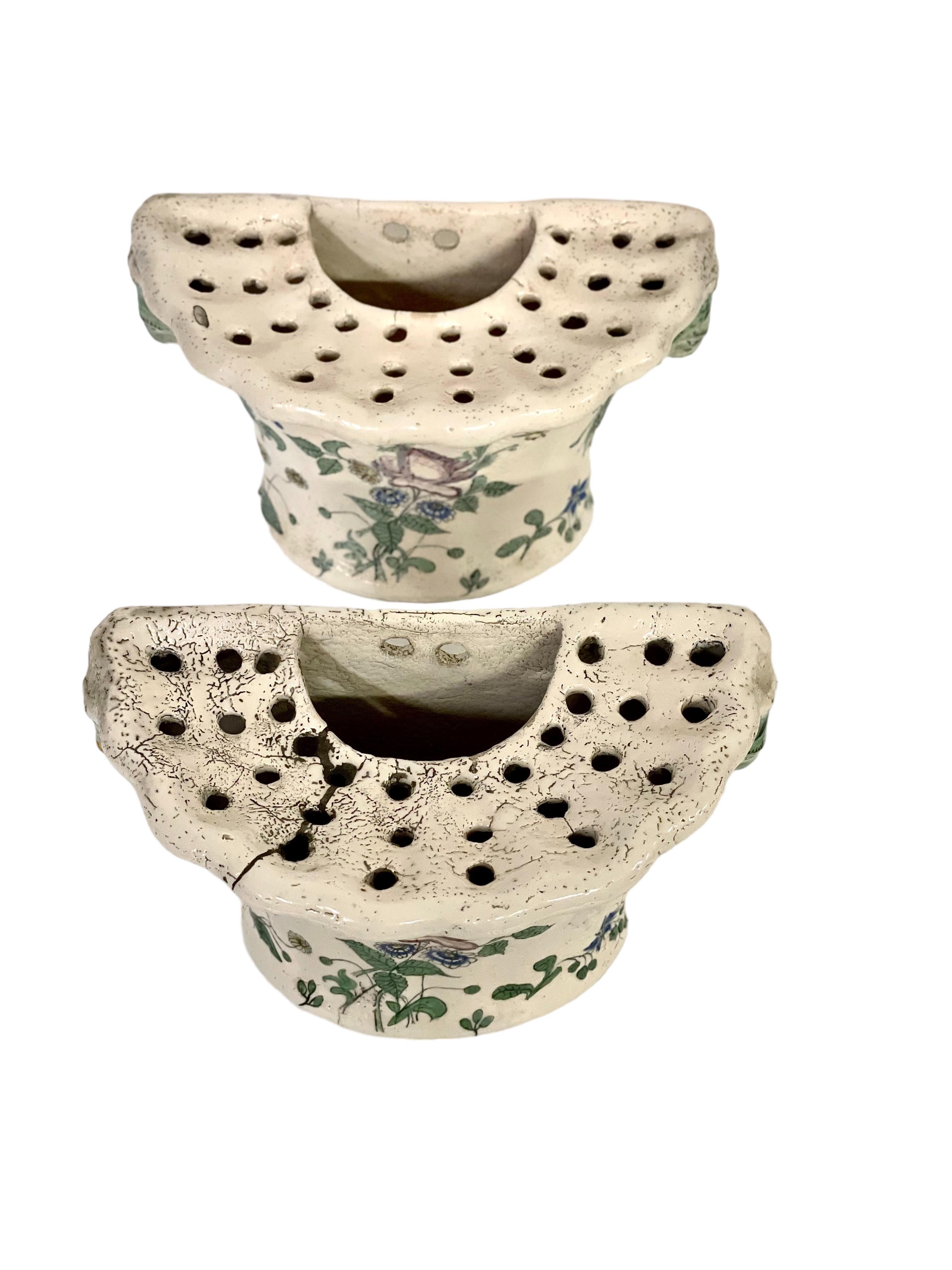 
Ein schönes Paar glasierter Terrakotta-Blumenvasen im rustikalen Stil aus dem 18. Jahrhundert. Jede dieser entzückenden Vasen hat die Form eines D, mit einem gadronierten Außenrand, dreißig Stiellöchern und einem Wasserreservoir. Die Dekoration ist
