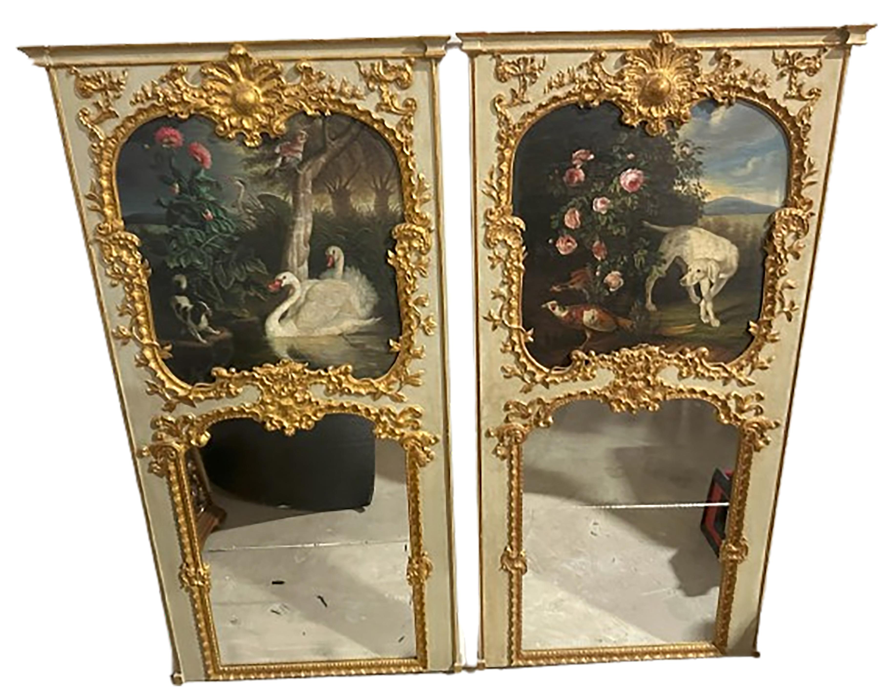 An exquisite pair of trumeau mirrors. Mirrored glass on the bottom halves of each. Top halves include a hand painted diptych of a pastoral scene. This includes a dog on the right looking towards a pair of swans on the left-hand side. These painted