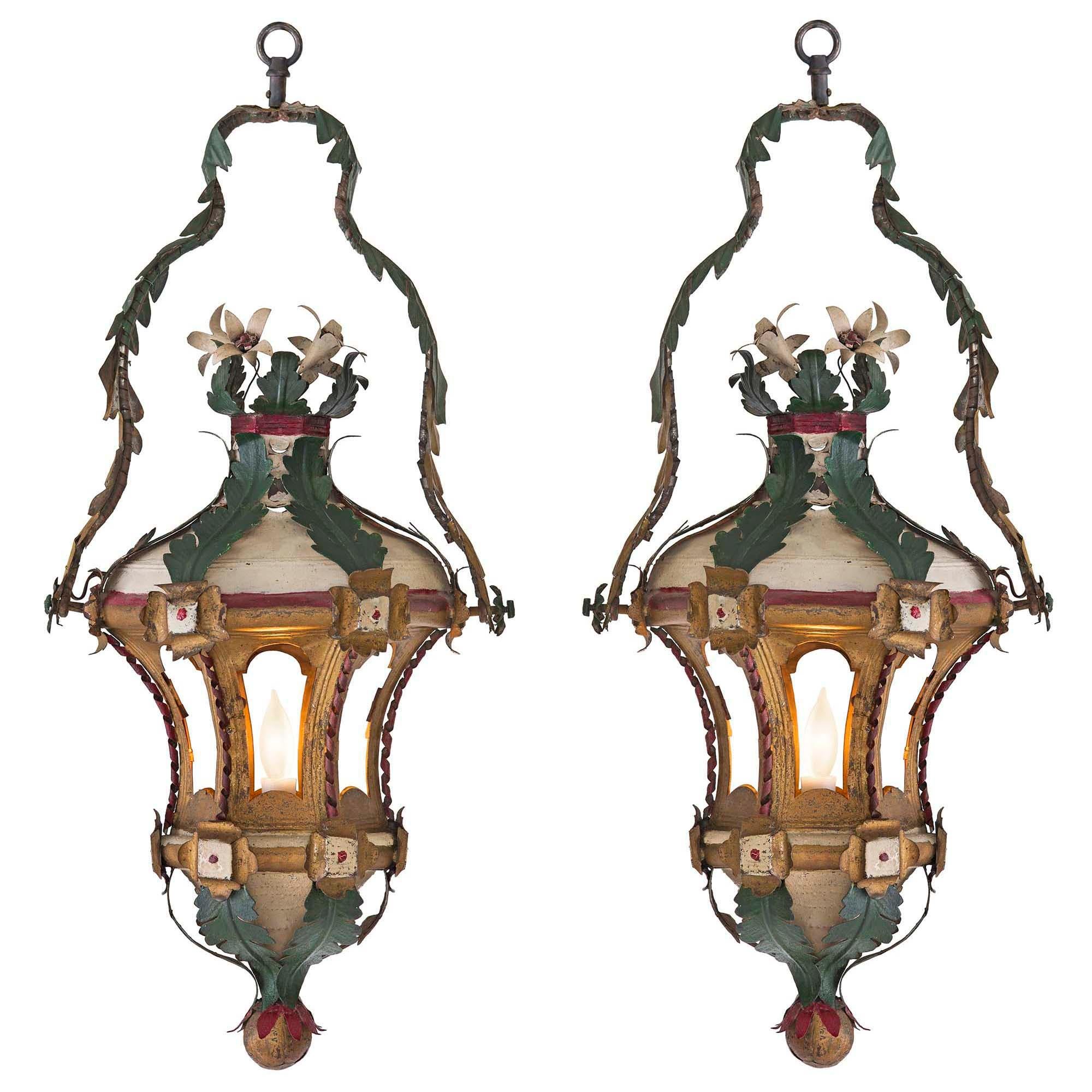 Coppia di lanterne veneziane dipinte e dorate del XVIII secolo, molto decorative. La coppia con una sfera dorata in basso conduce a foglie verdi a 'S' con punte rosse. La fascia a forma di esagono sopra ha delle riserve ad ogni angolo. I sei lati