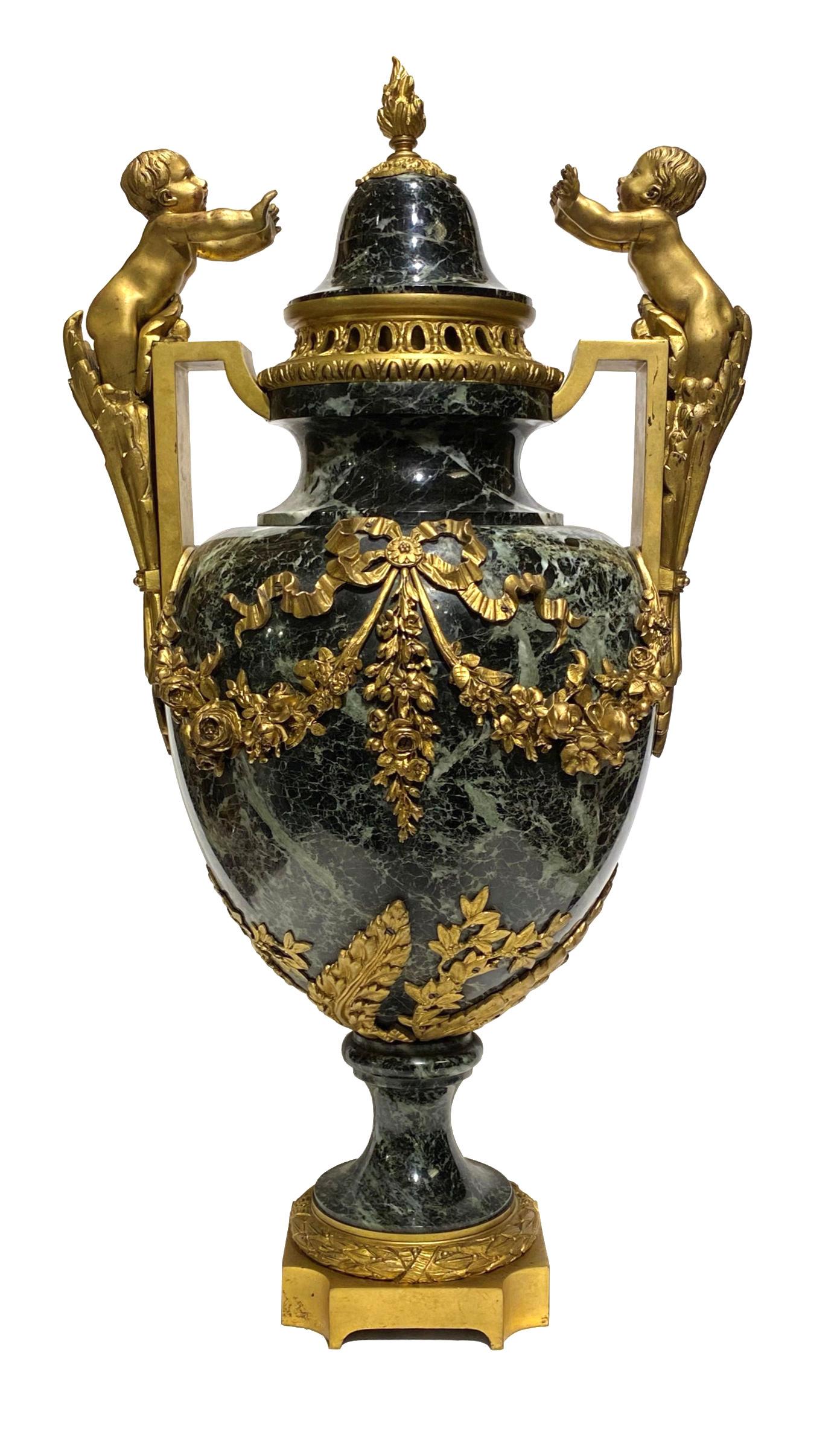 Paire d'urnes en marbre de style Louis XVI, de grande taille et de très belle qualité, datant du XIXe siècle, montées en bronze doré et ornées de chérubins.
