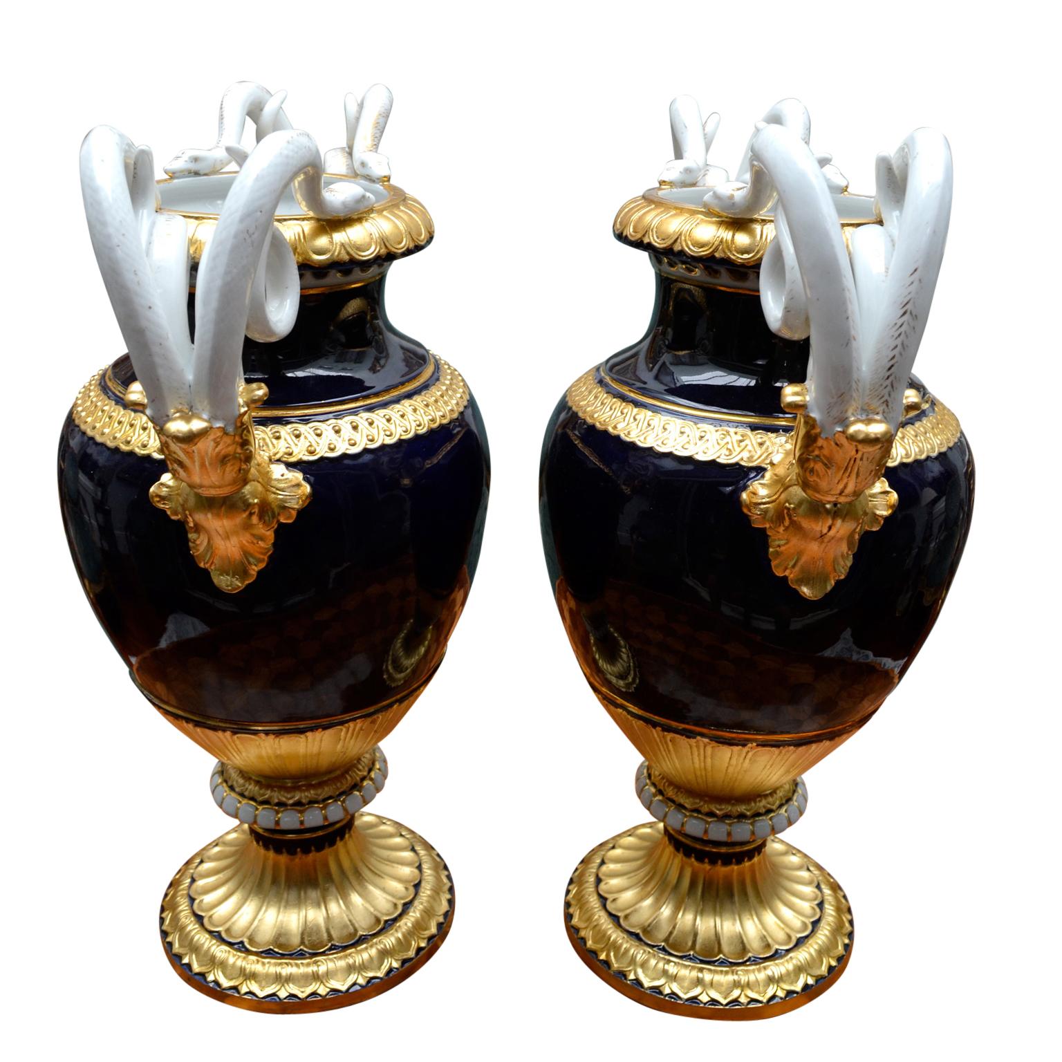 A pair of 19th century neoclassical baluster form vases, the gilt gadrooned rim flanked by paired coiled serpent handles terminated with acanthus leaves above a band of VItruvian scrolls, the shoulder with braid, the lower section with a further