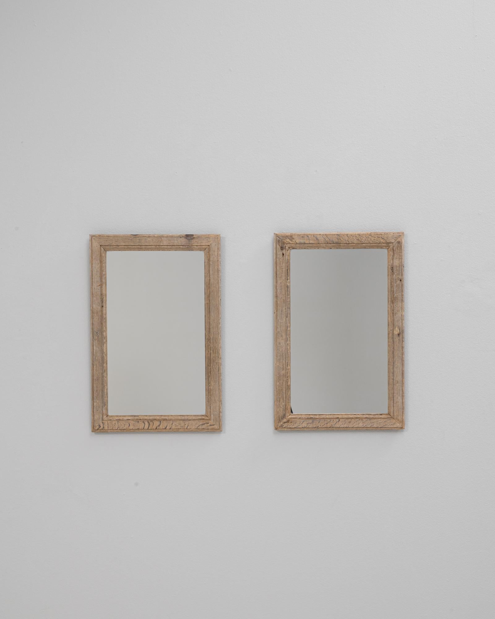 Questa coppia di specchi da parete in rovere francese del 1900 offre un'estetica semplice e senza tempo che affonda le sue radici nell'artigianato tradizionale. Ogni specchio è caratterizzato da una cornice rettangolare realizzata in rovere