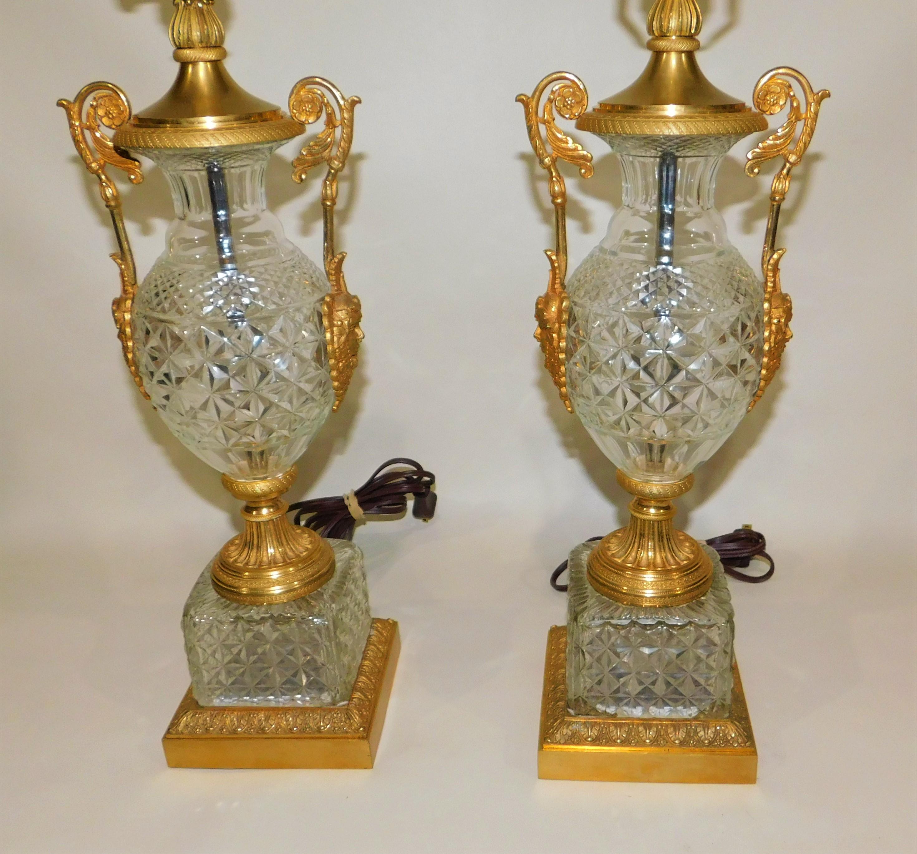 Pair of circa 1920 Austrian cut crystal glass and gold gilt bronze table lamps. Each lamp has two figures on each of the Roman wine God Bacchus on them. Each lamp measures 27.5 inches high to the top of the acorn finials, the shades are 17 inches