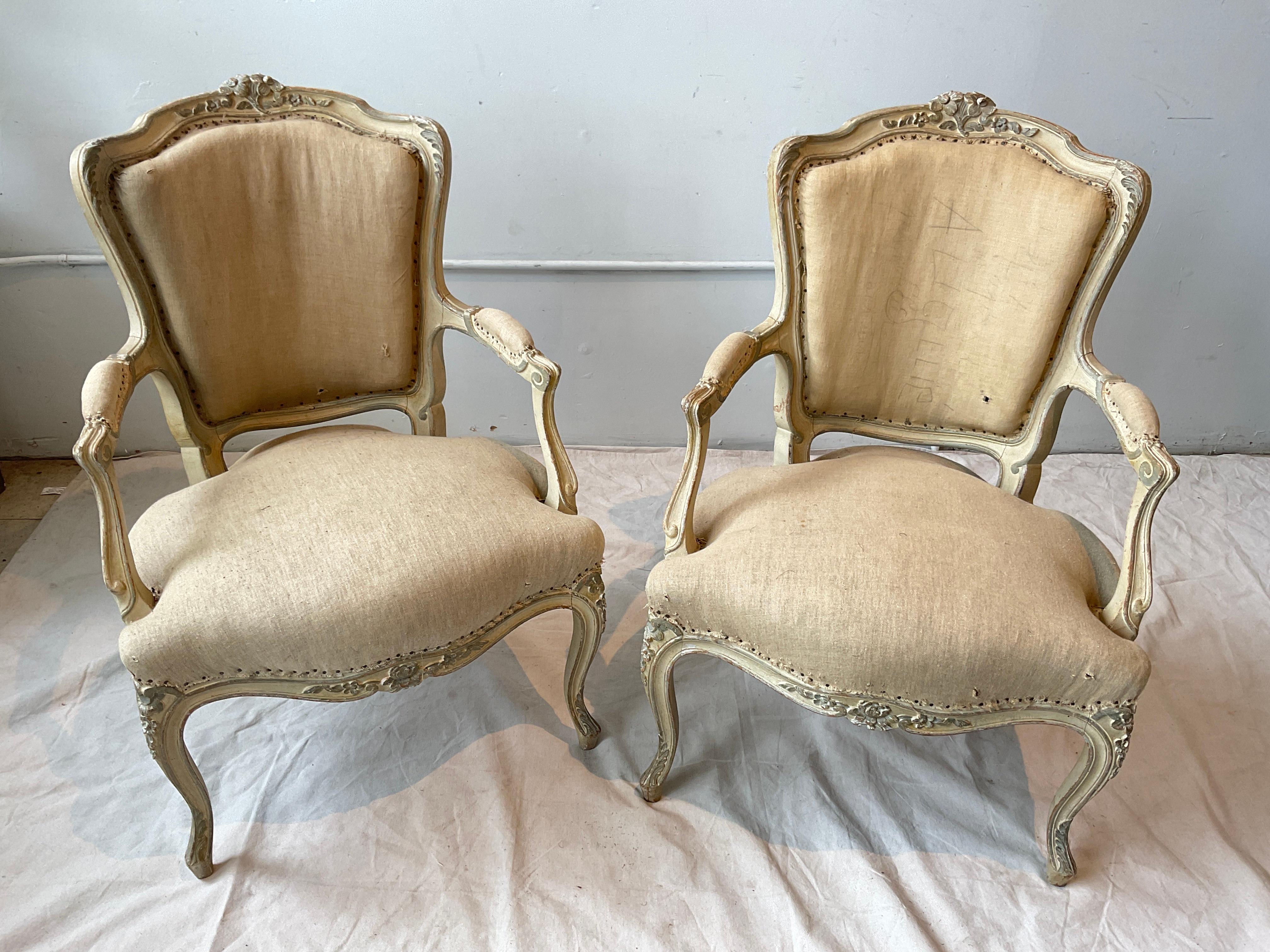 Pair of 1920s French Bergere chairs. Beige with grey accents.
Needs reupholstering. Has writing on fabric.